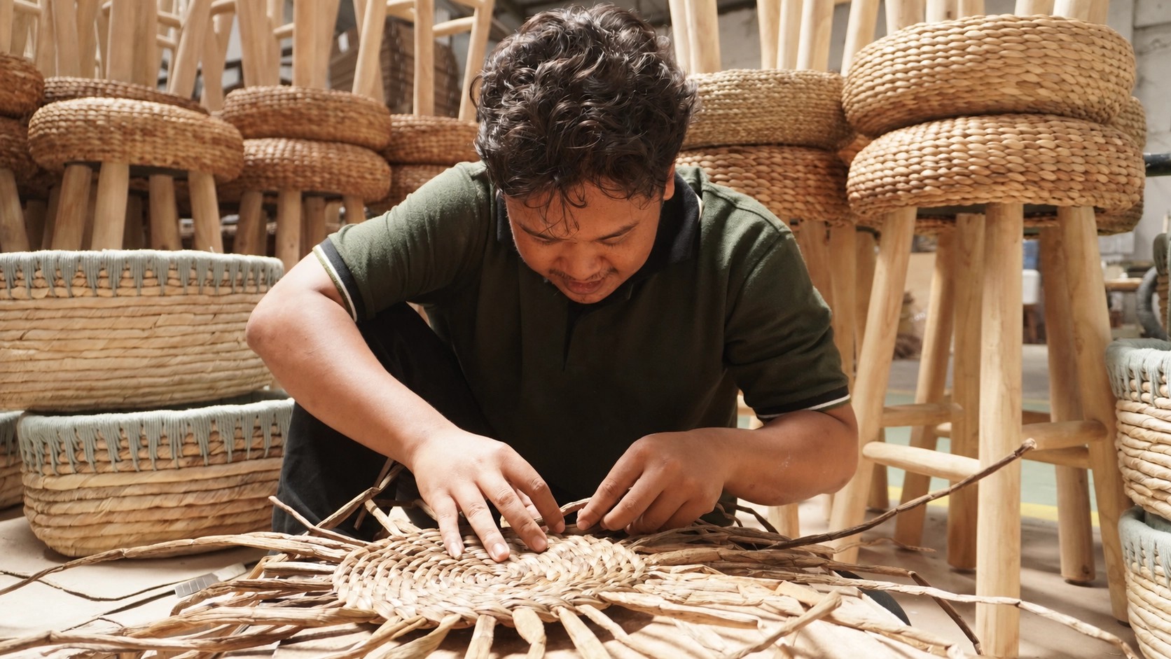 gentleman hand weaving a wicker stool with waterhyacinth and stools behind him