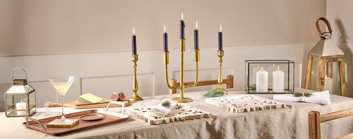 Brass Candlesticks and selection of candle light on dinner table setting.