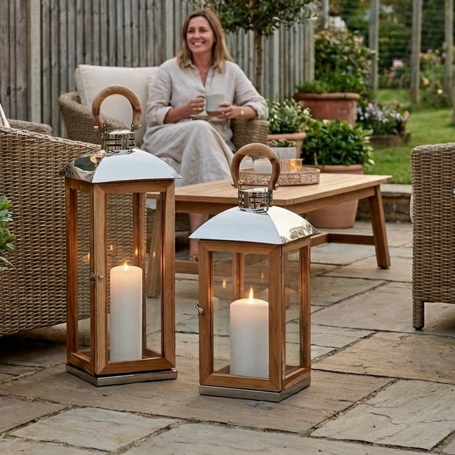 wooden candle lantern on patio with lady drinking tea