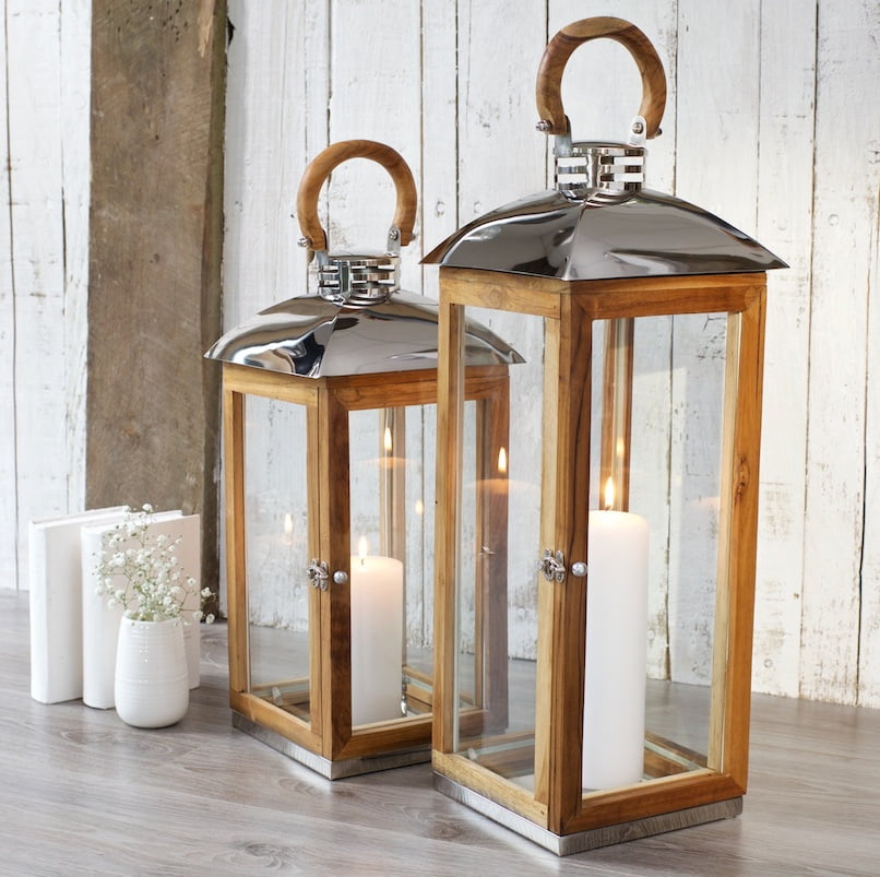 Rustic wooden candle lanterns on the floor with flowers