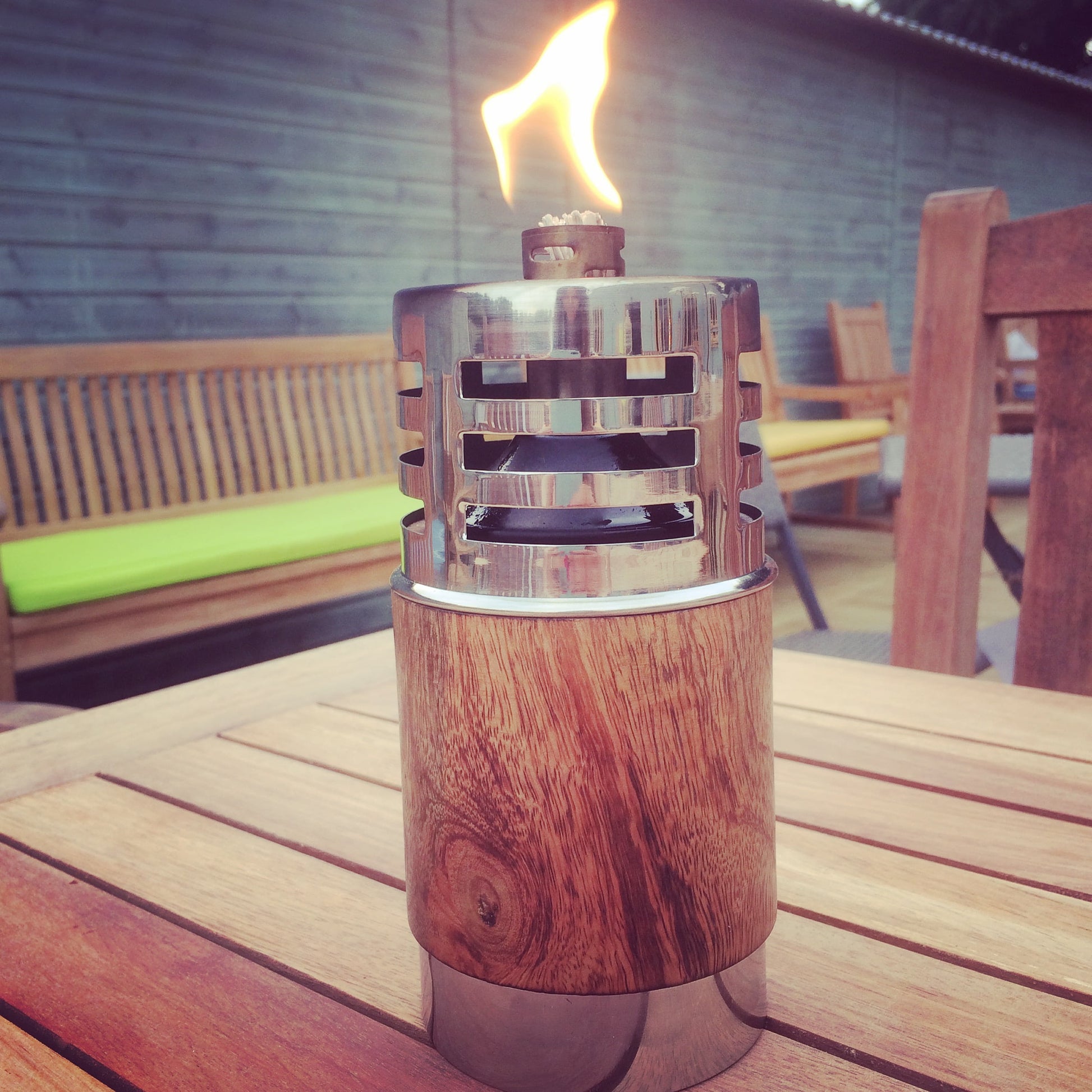 garden oil lamp with flame on patio table