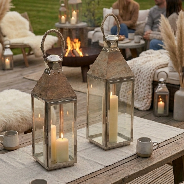 tall garden lanterns on dinner table outside with people behind
