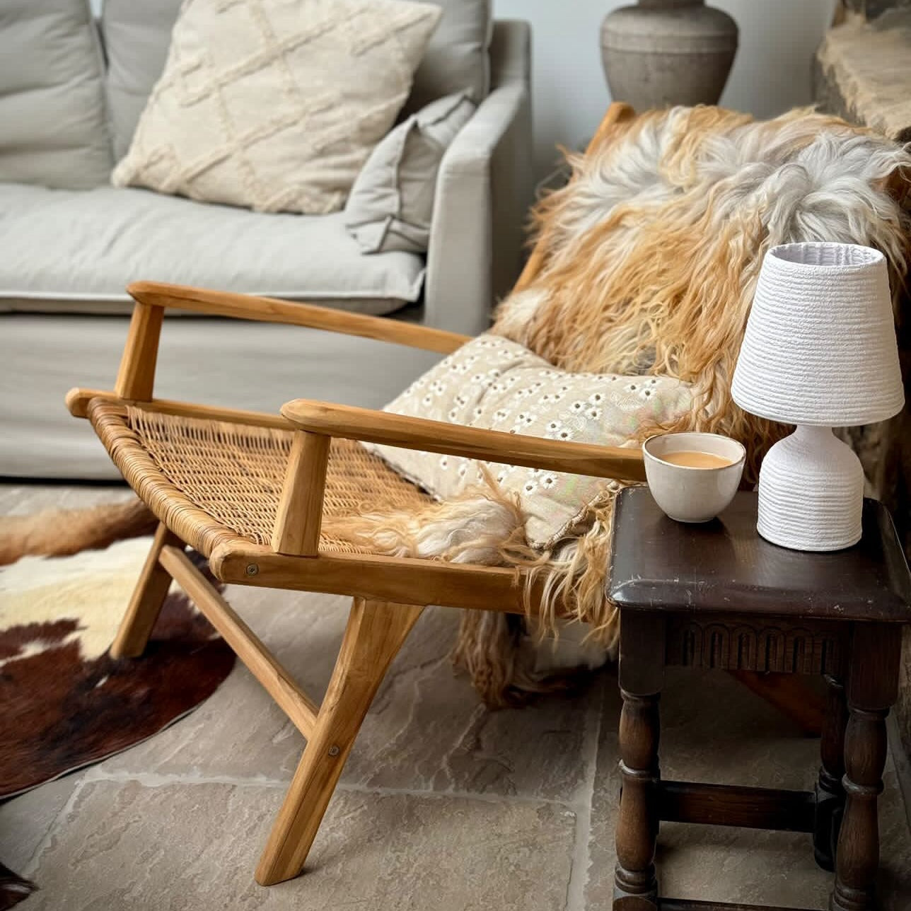 Rattan arm chair with reindeer hide and cup of tea in cosy setting