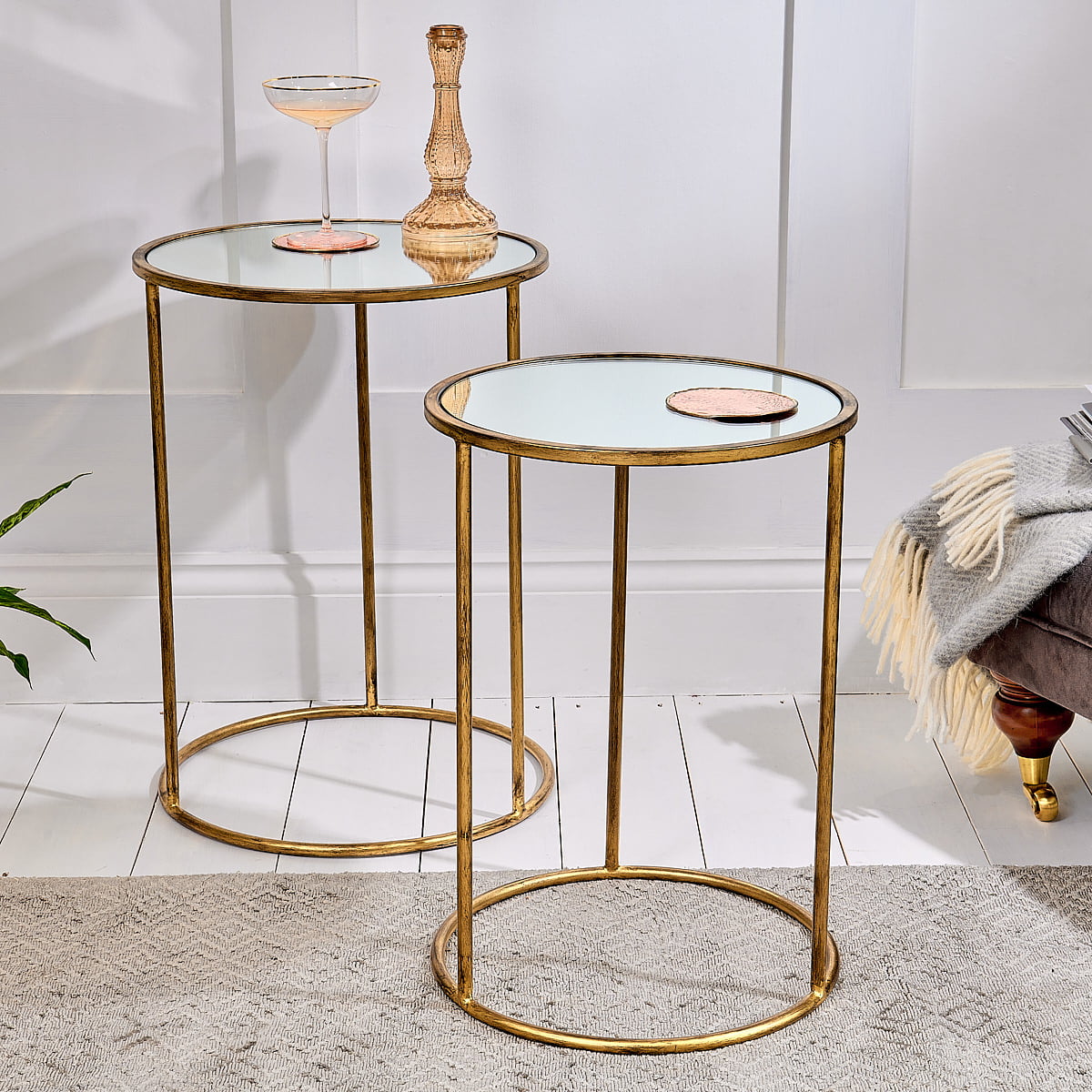 Mirrored nest of tables on white floor with rug