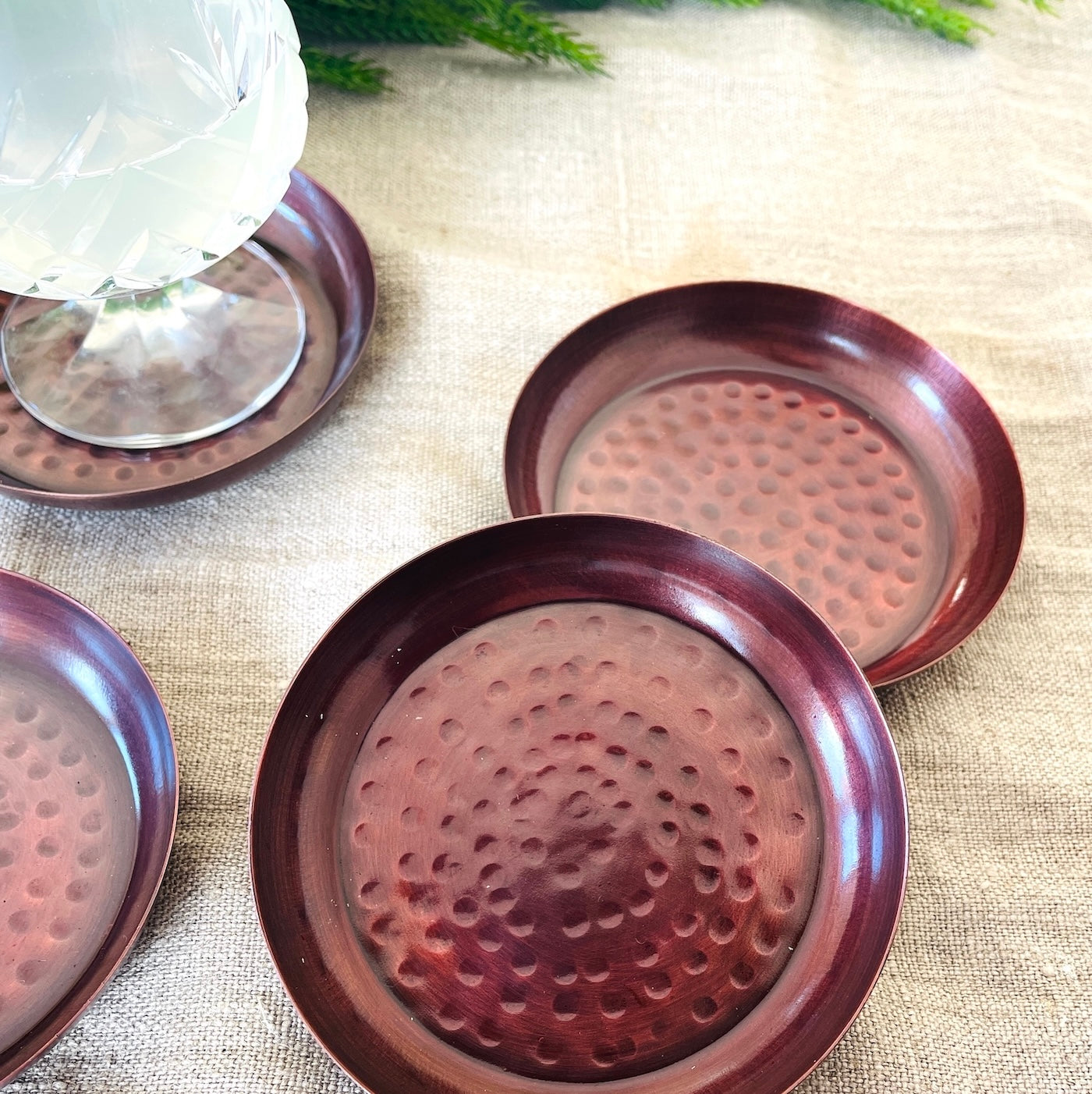 Antique copper coasters on dinner table with cocktail glass