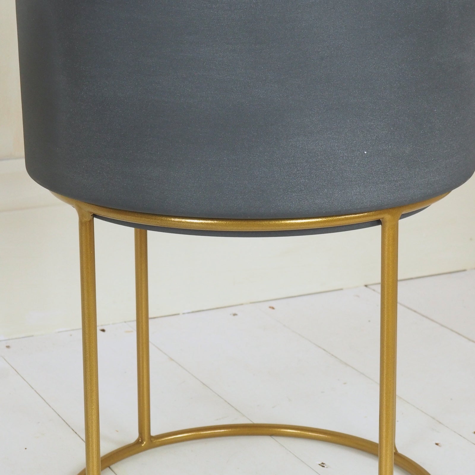 Detailed photo of grey and brass plant stand