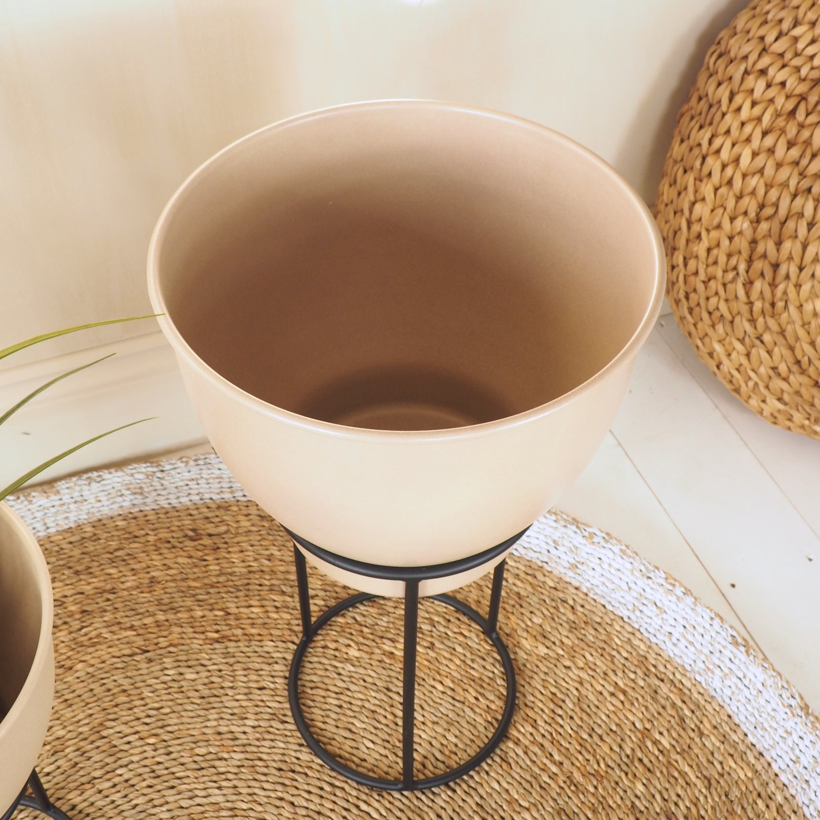 Beige indoor plant pot on stand with wicker rug
