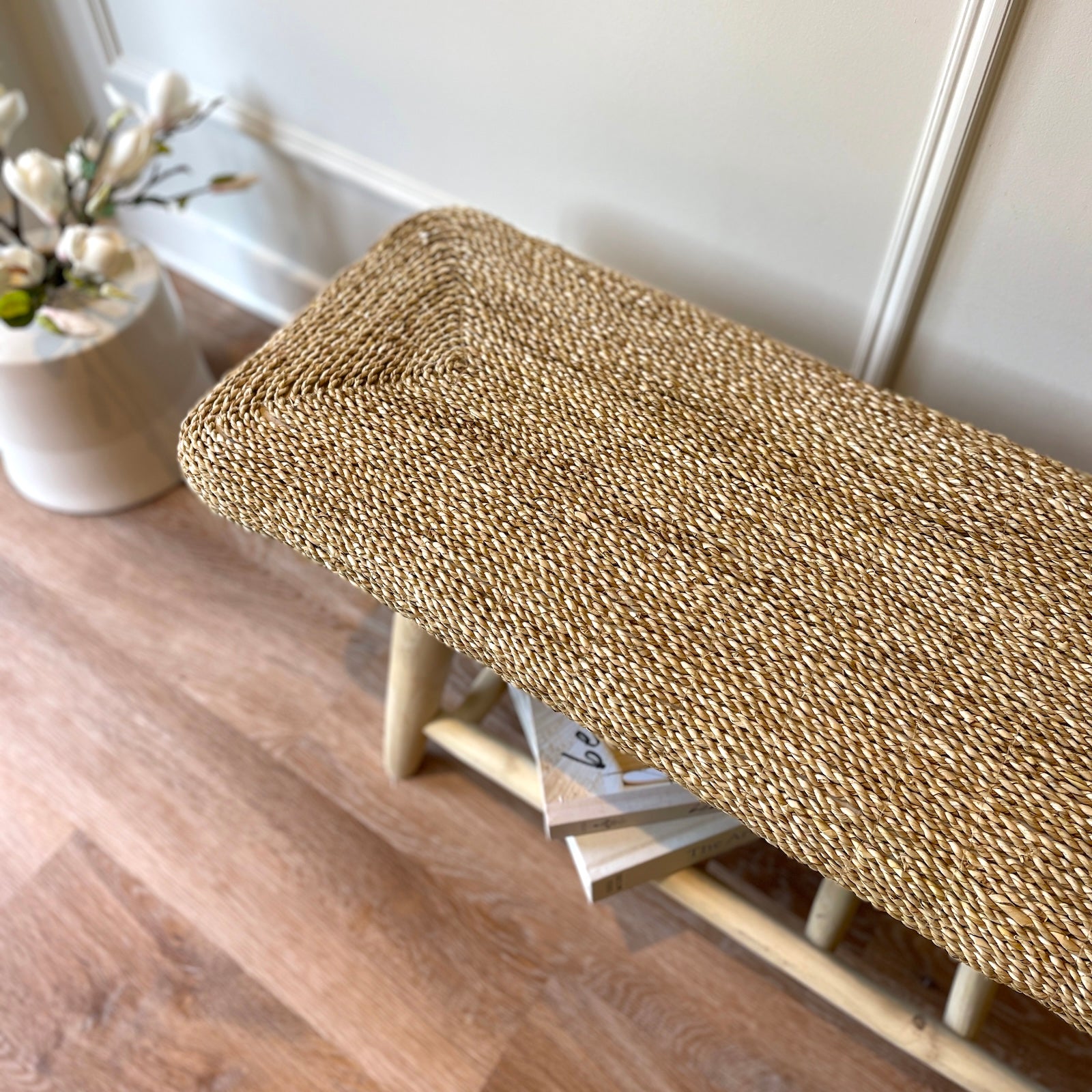 wicker bench in hallway with flowers