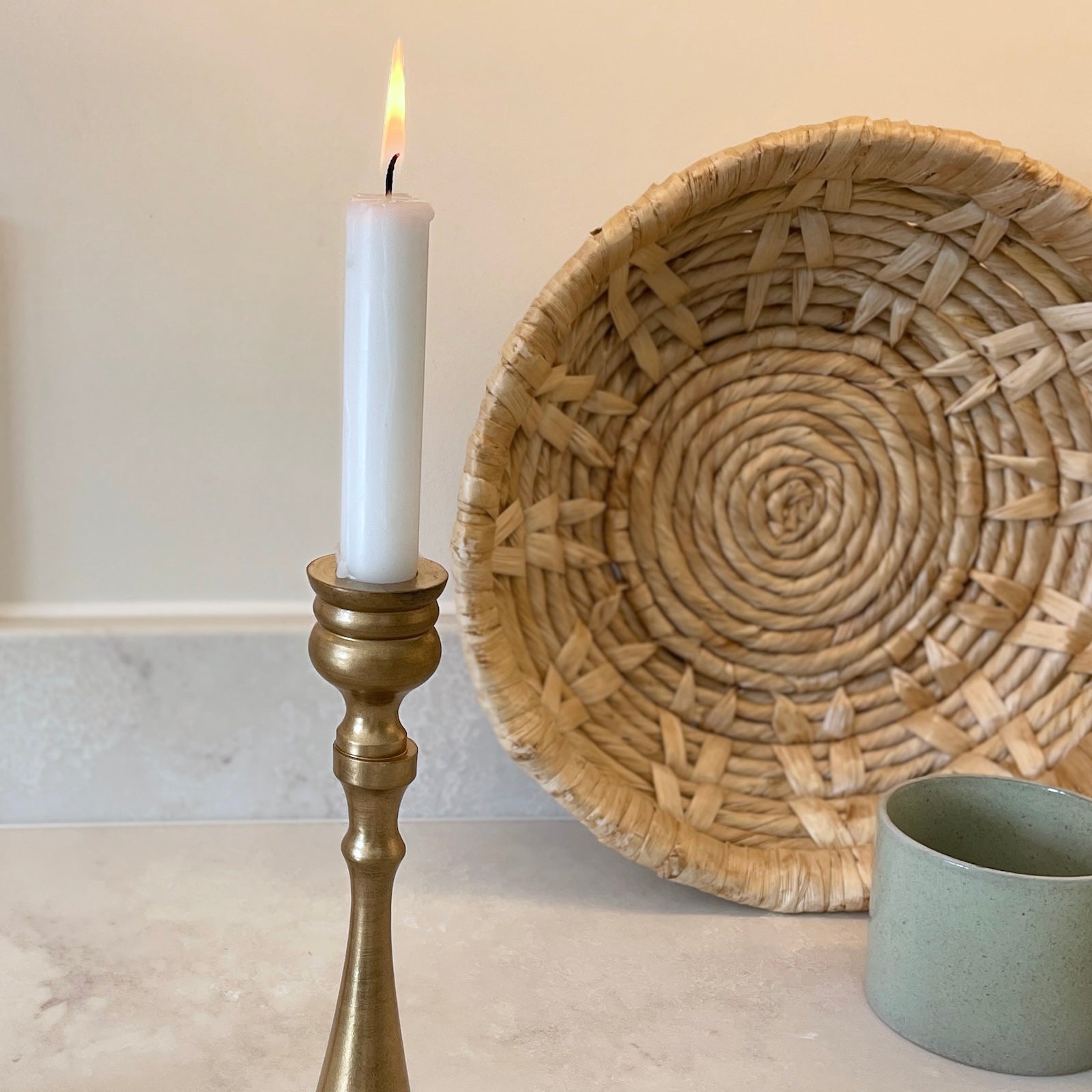 candlestick and wicker bowl on marble kitchen counter top