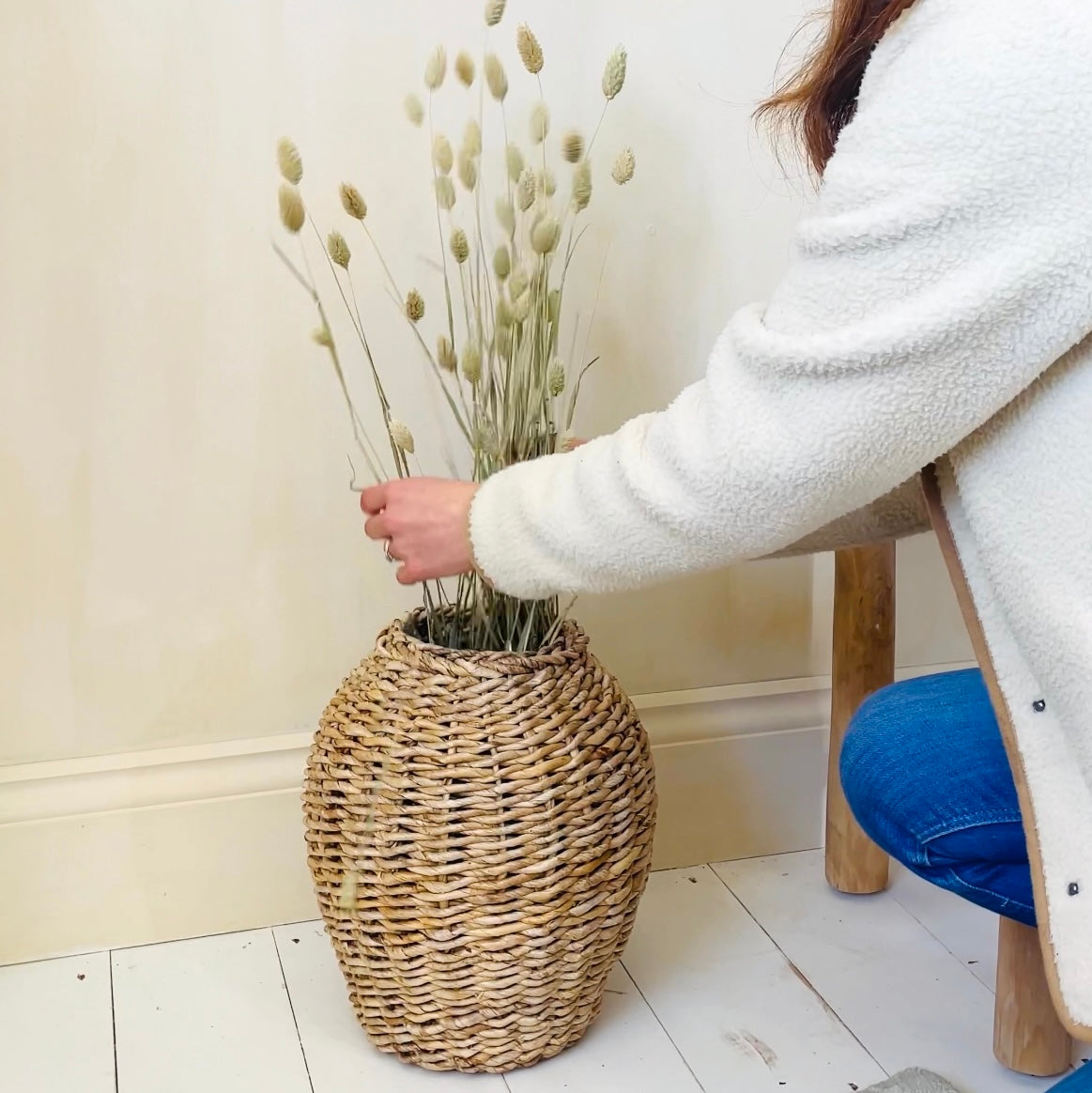 Rattan vase with women arranging flowers
