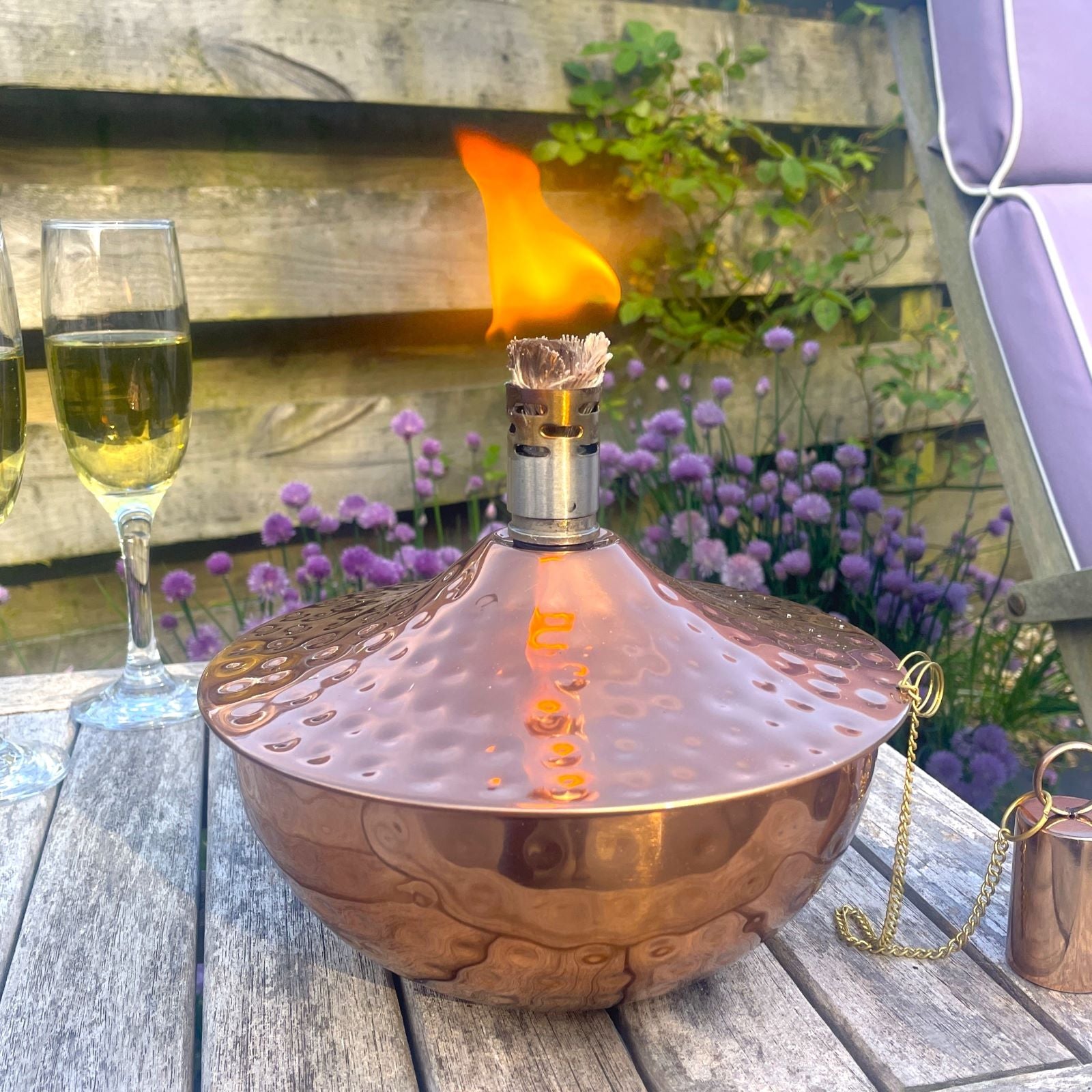 Copper outdoor citronella oil lantern in garden with drinks and nature