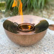 Garden gel lamp on table in front of plants and drinks.