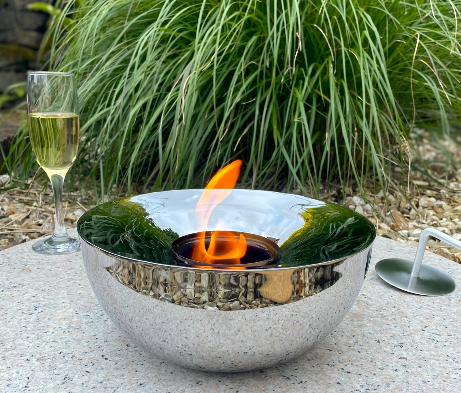 Silver outdoor gel lamp in garden with drink and nature