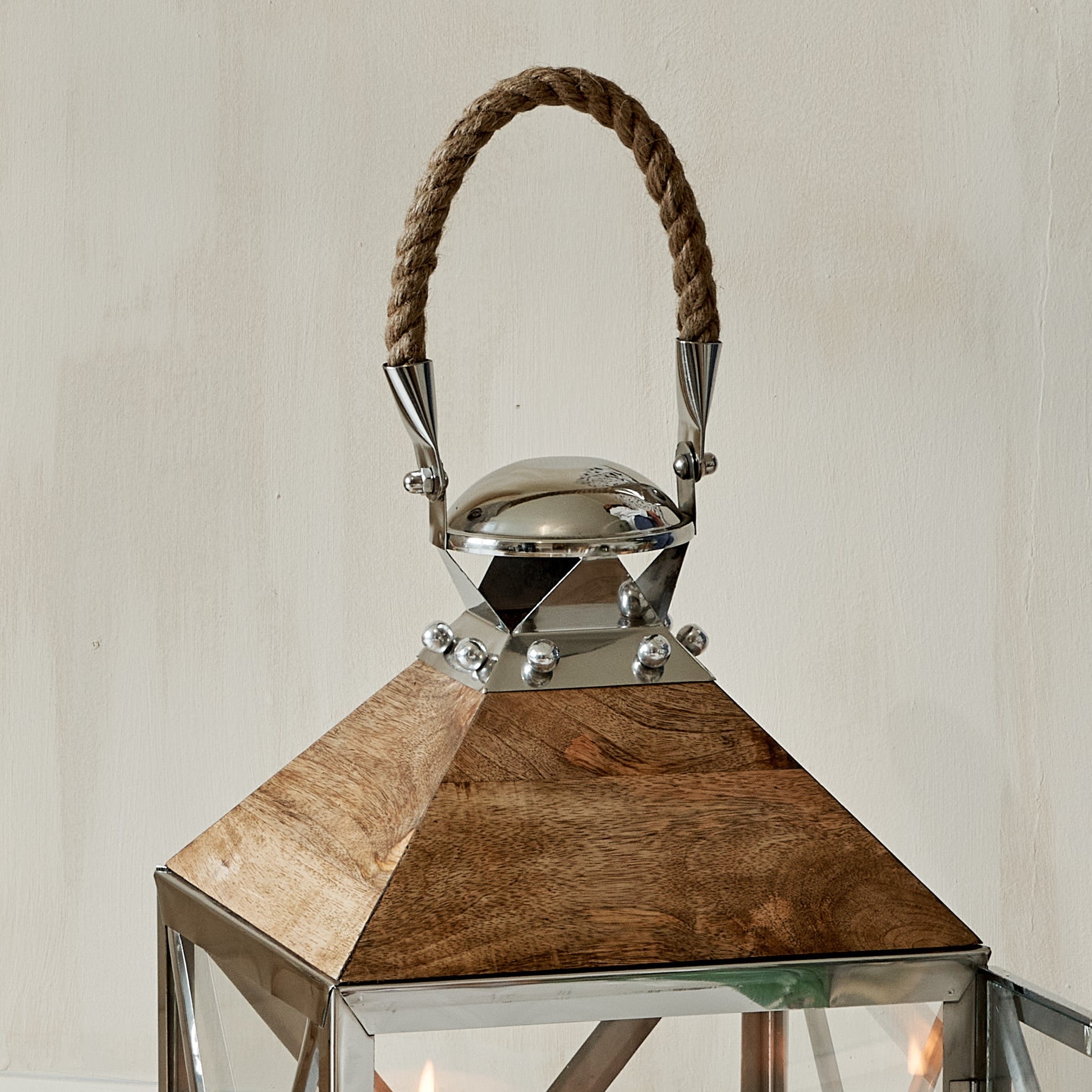 Close up of wooden top and rope handle of Silver and mango wood lantern