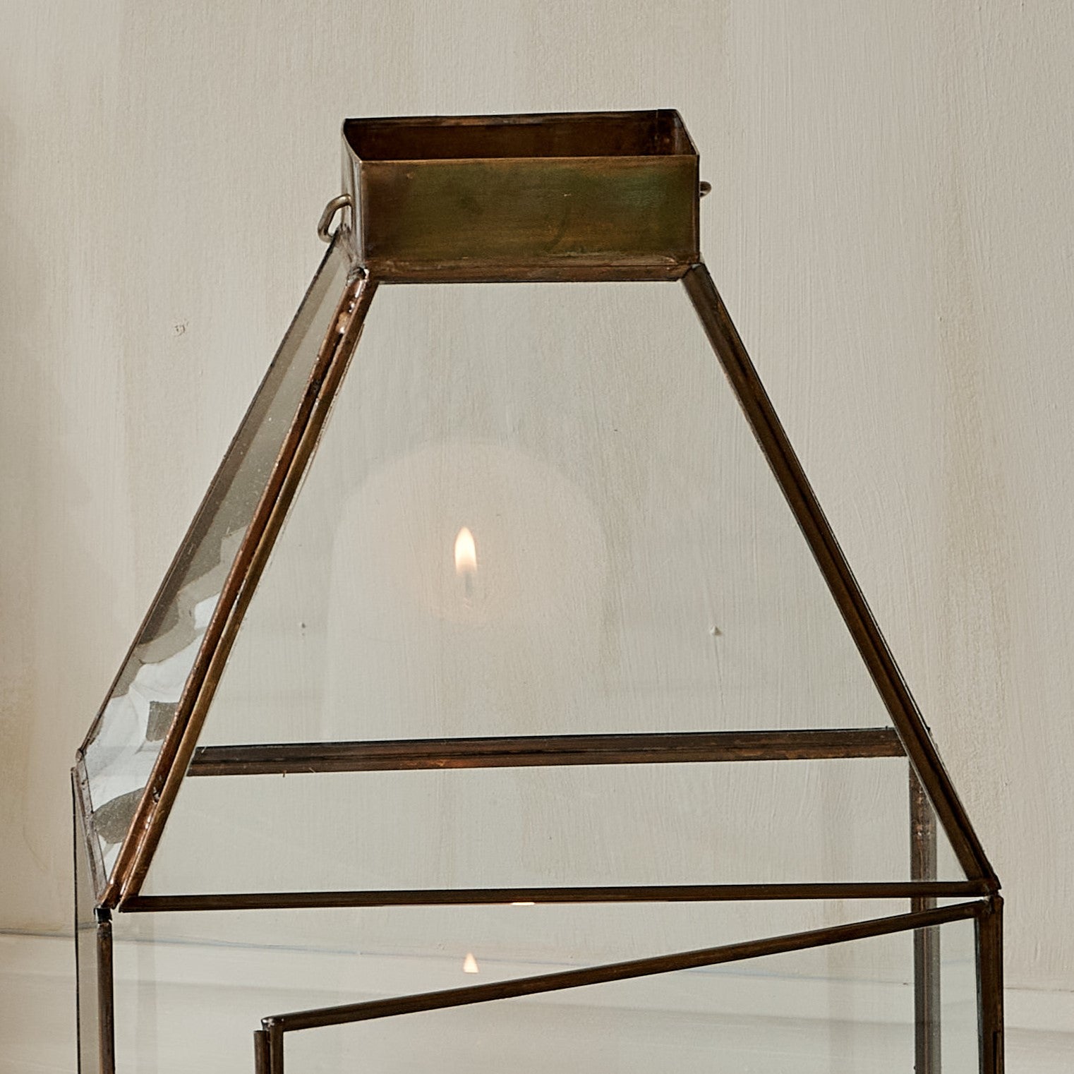Close up of top of large glass and metal candle lantern square