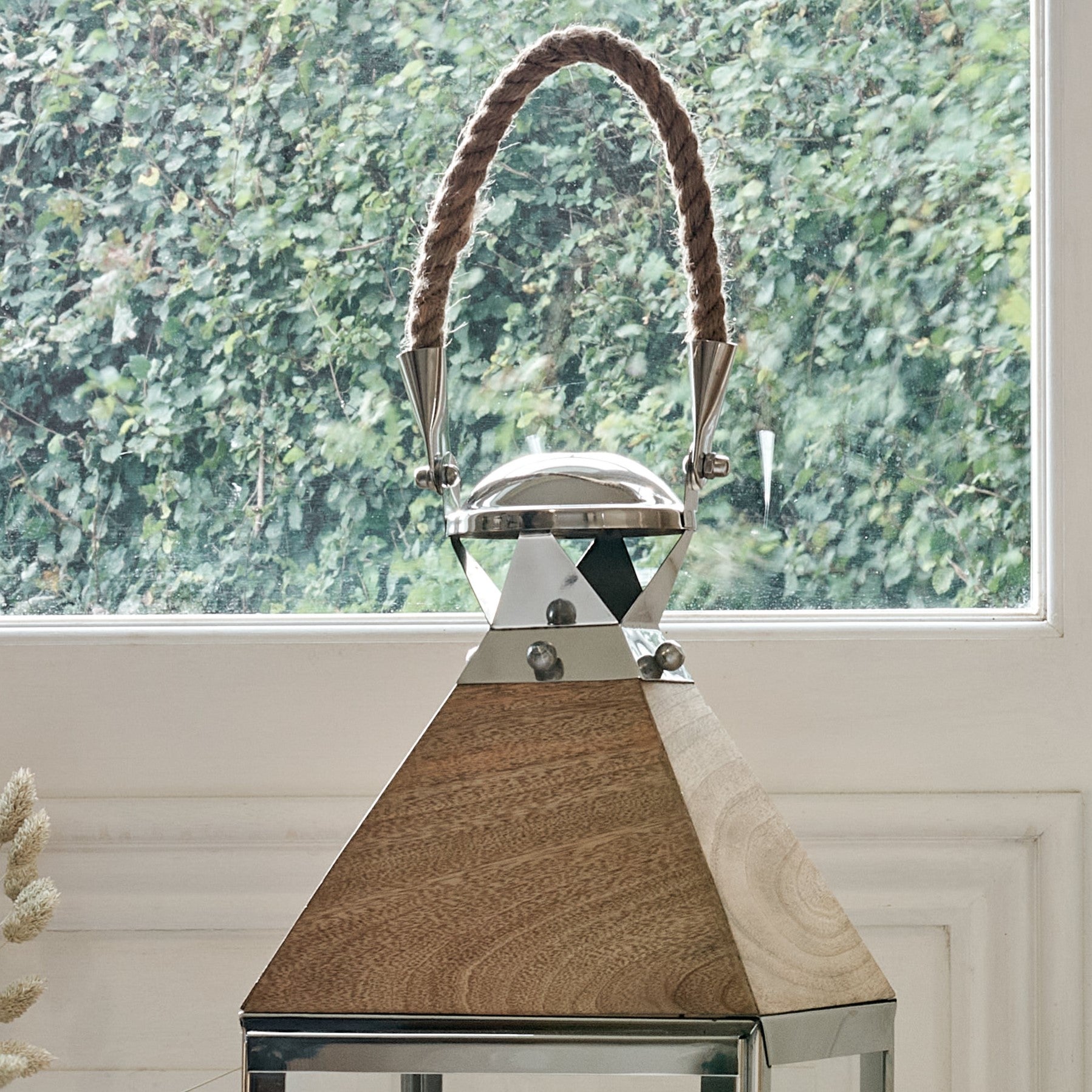 Close up of rope handle and wooden top of mango wood and metal candle lantern