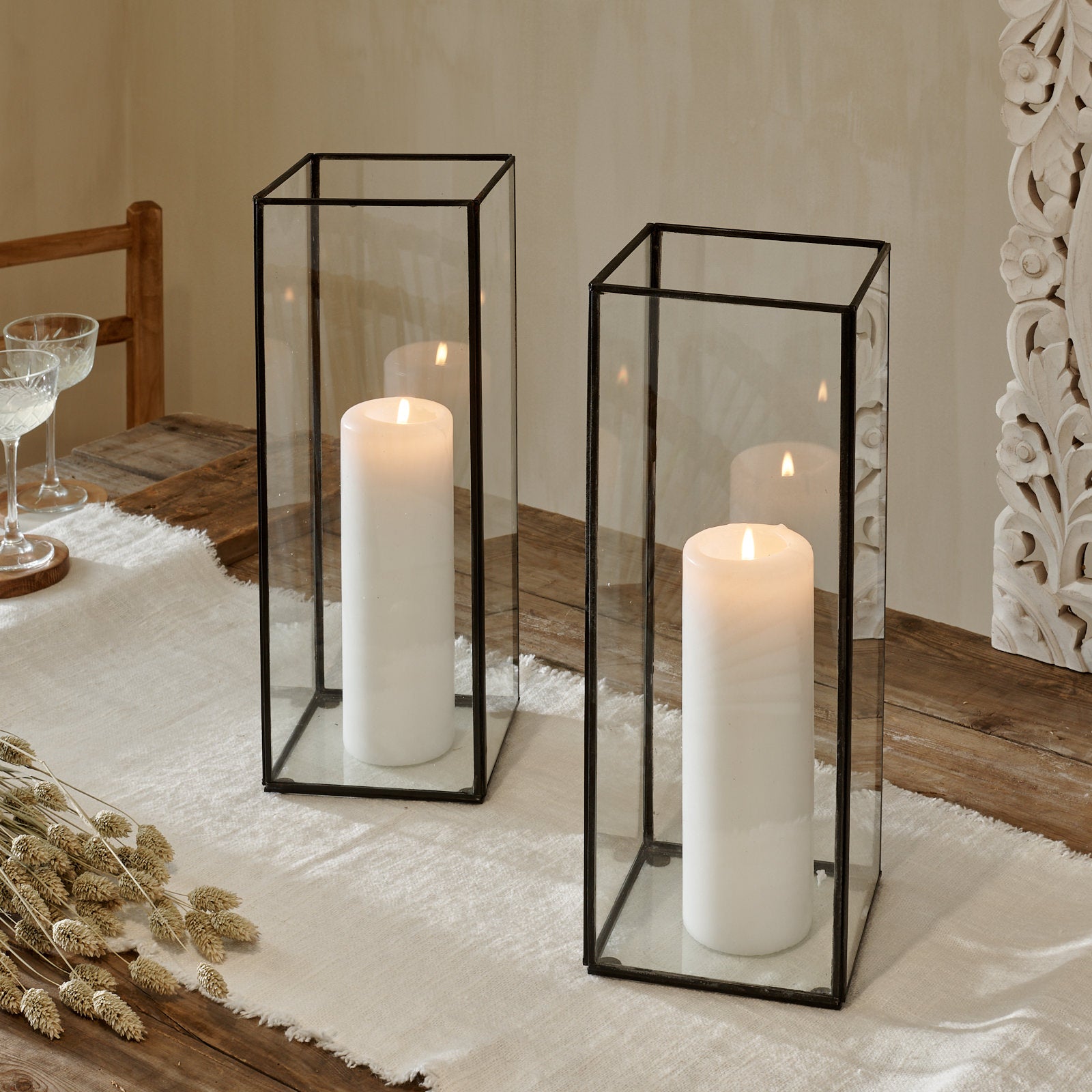 Glass terrarium lantern on cotton runner on wooden table