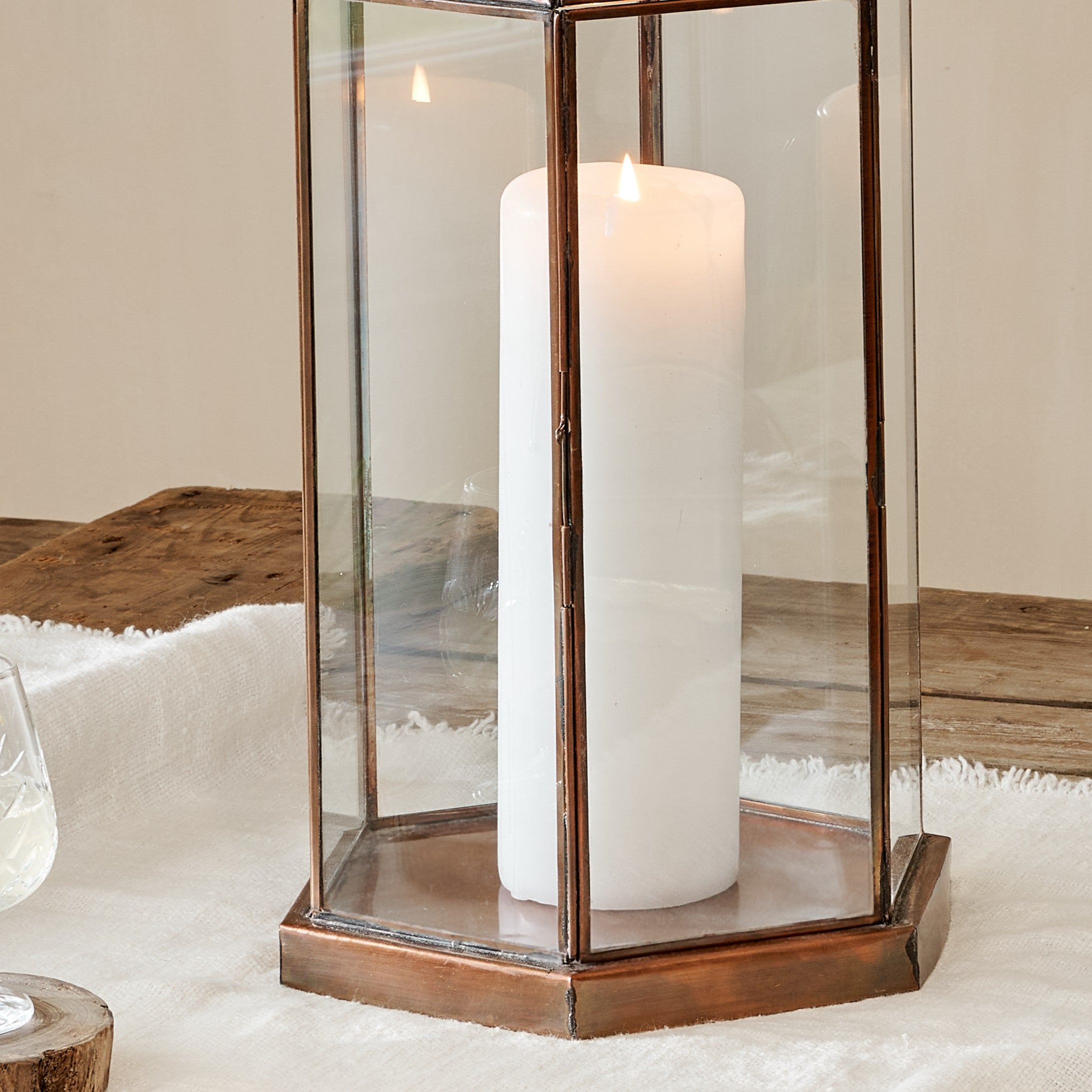 Close up of bottom of Hexagonal brass lantern with white pillar candle