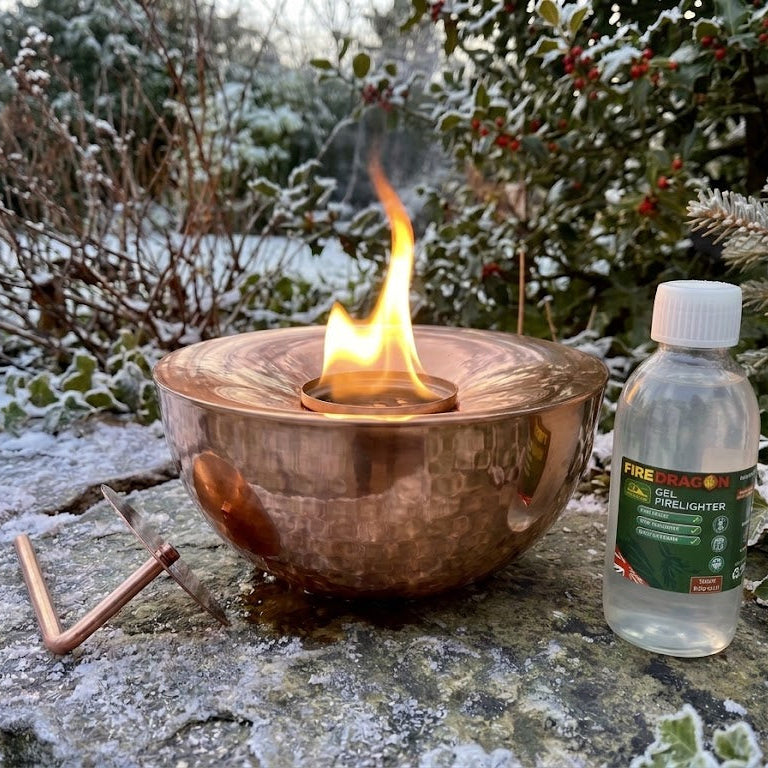 Large Hand hammered copper gel lamp or fire pit lantern with gel fuel in a winter garden 