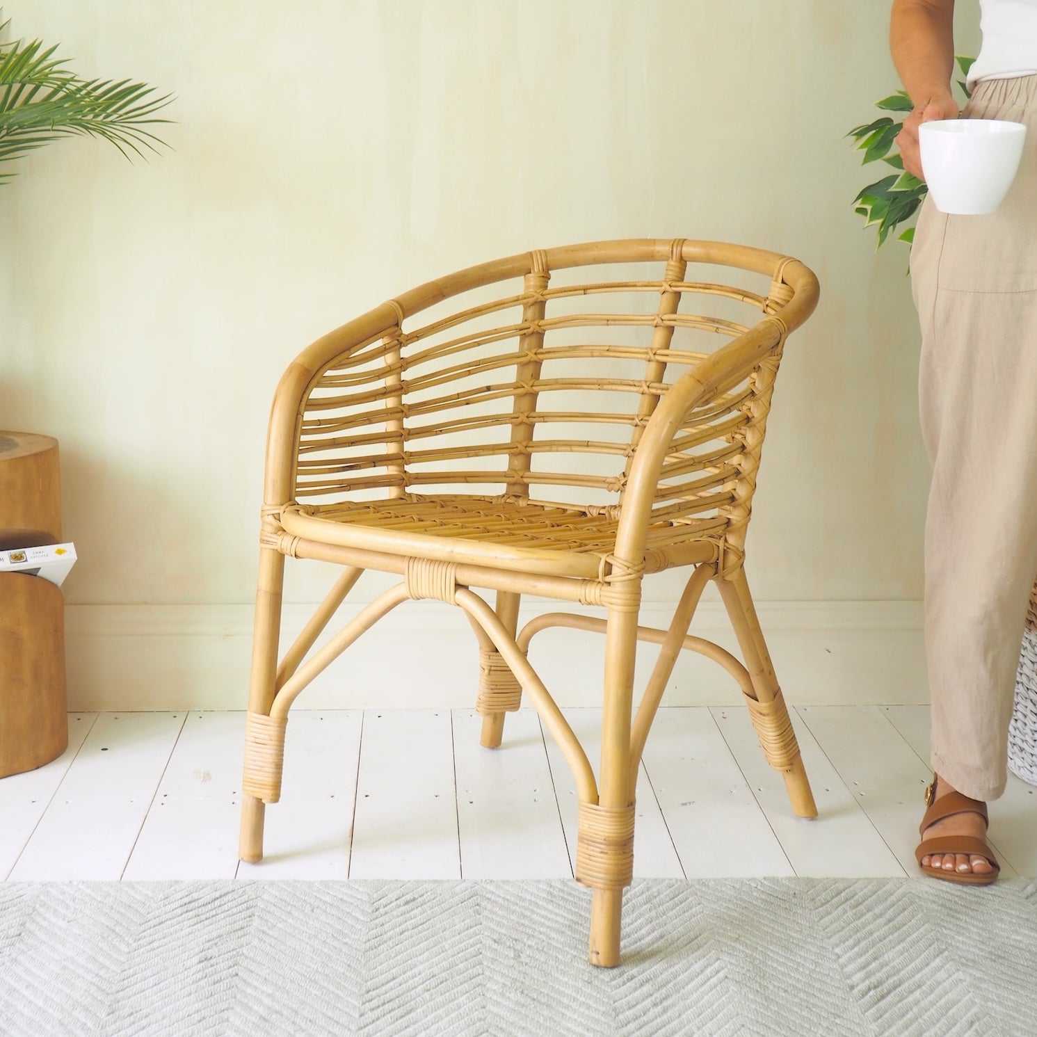 Bamboo arm chair on wood floors with girl holding mug