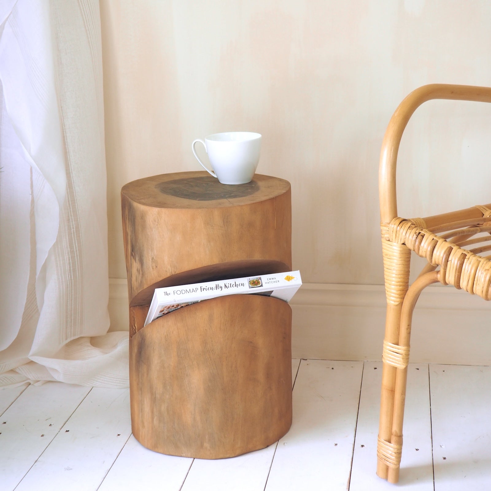 Rustic wood coffee table in bedroom with wicker chair and curtain