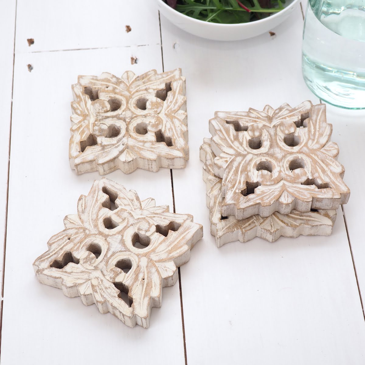 Wood carved drinks coasters on white wooden table