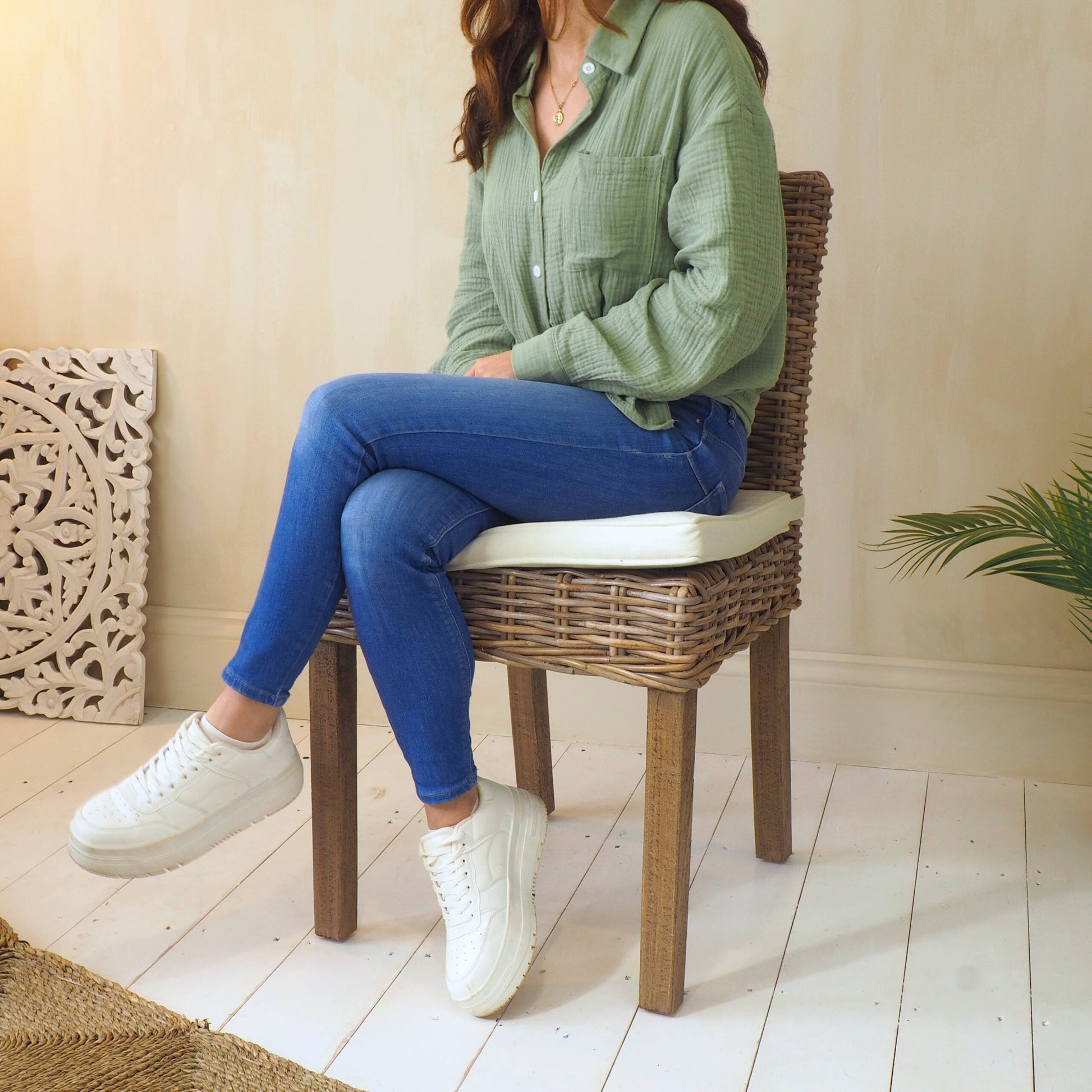 Woman sat on natural wicker dining chair