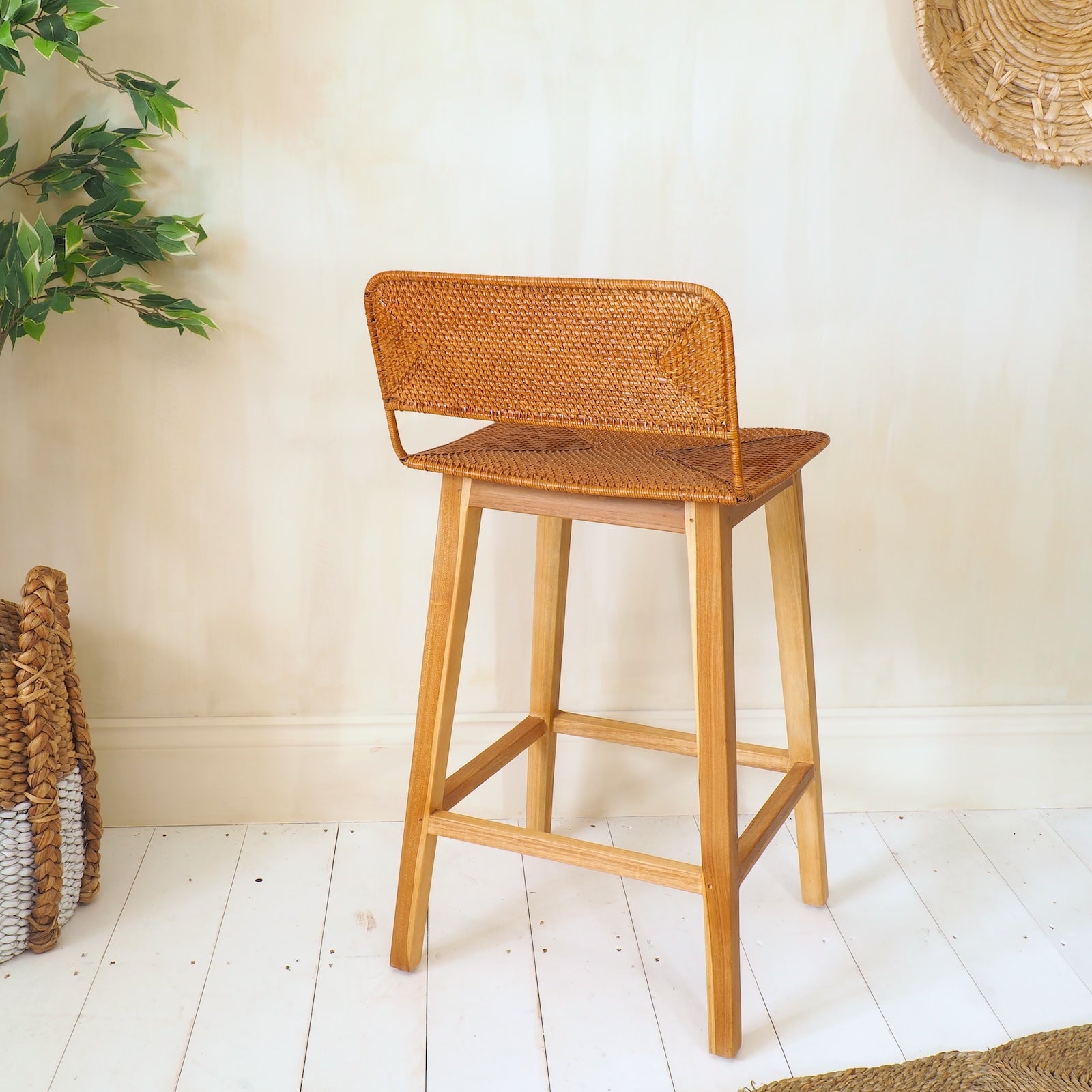 Rattan kitchen stool on white wooden floors with plant
