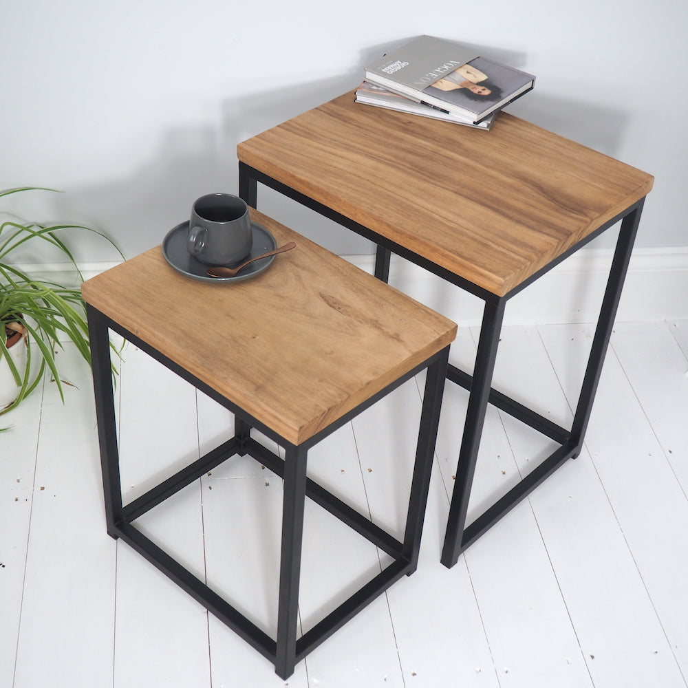 Set of two wooden tables nesting with book and mug