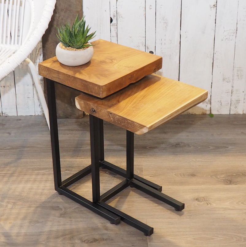 Nest of two tables together on wooden floor in front of white wood wall