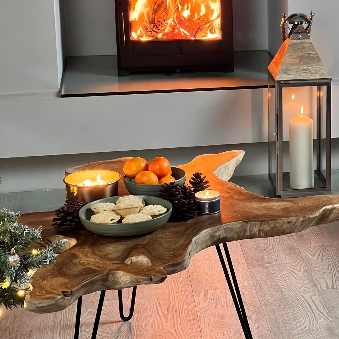 rustic wooden coffee table in cosy christmas setting with mince pies and log burner