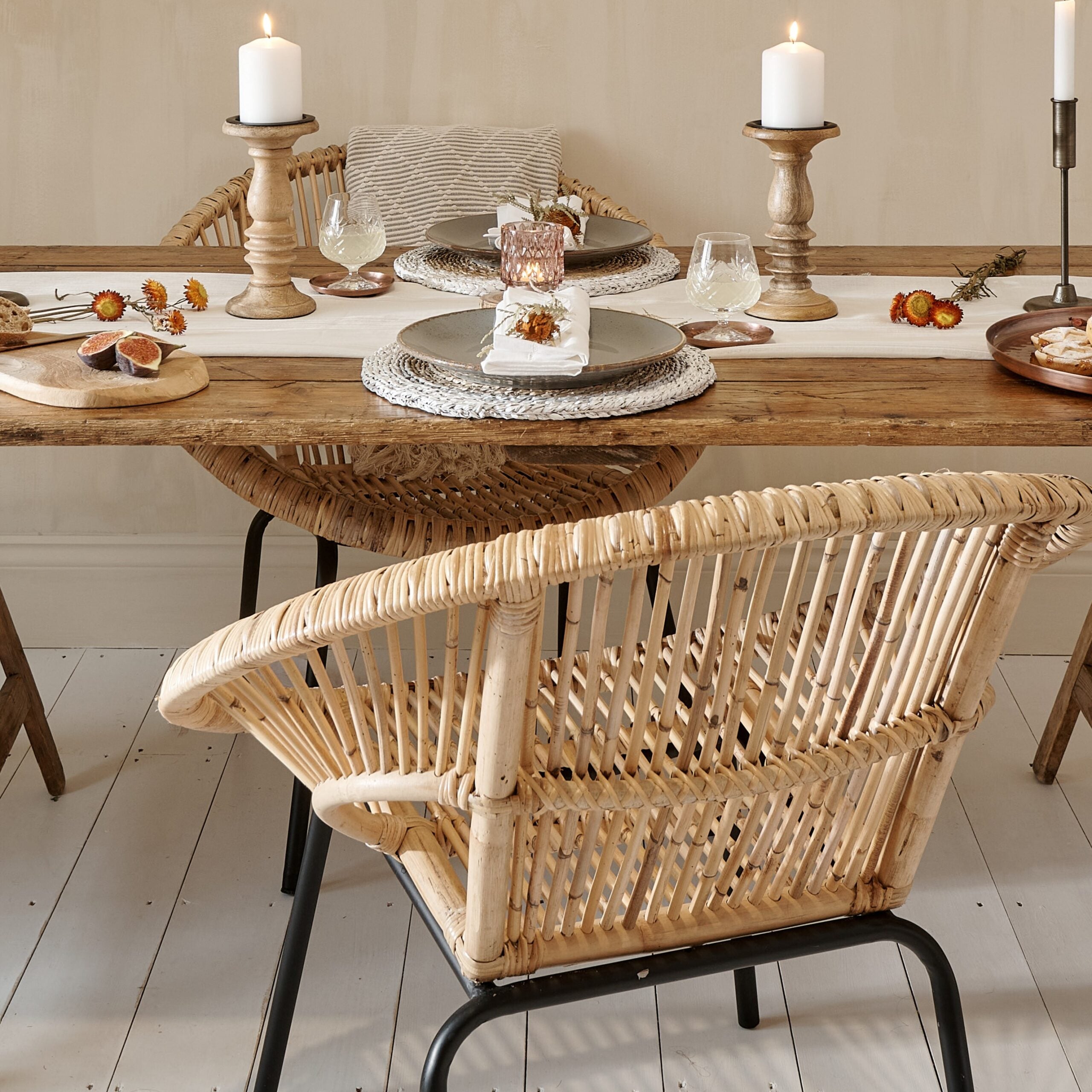 Bamboo tub chair by dining table, will with candlesticks and table decor