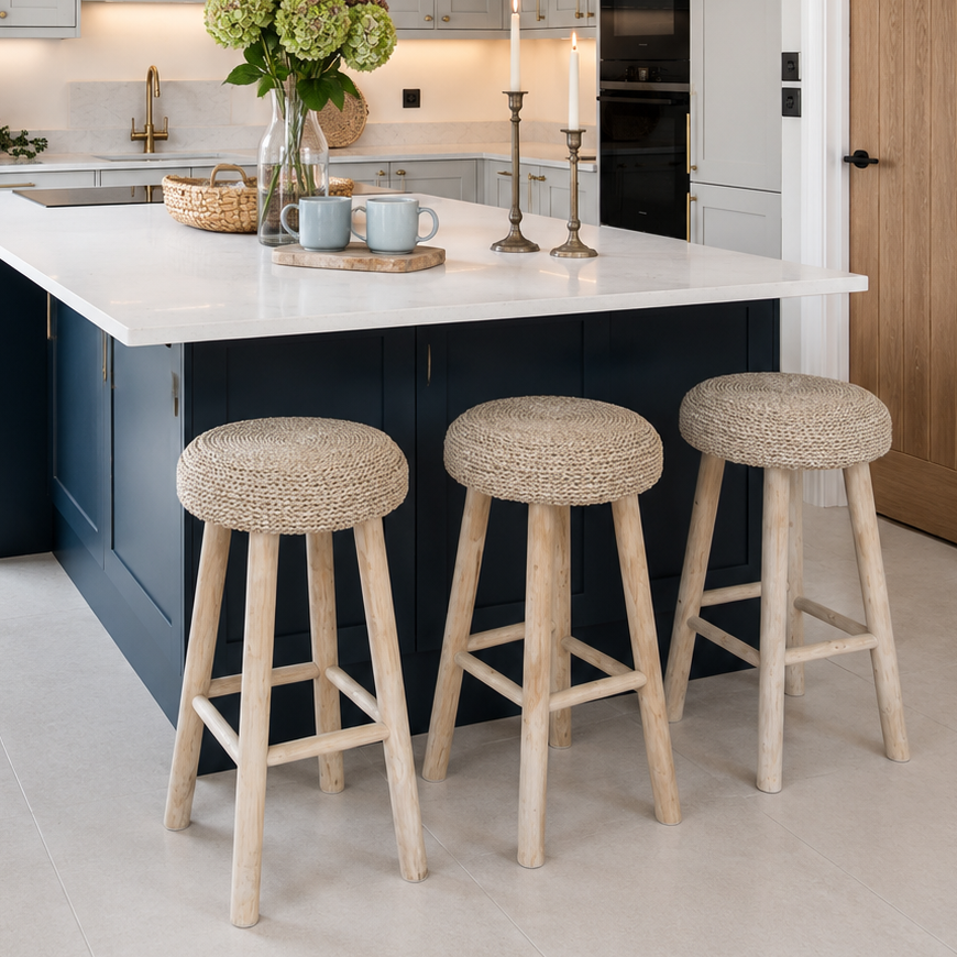 seagrass kitchen stools at marble kitchen island with candlesticks and vase