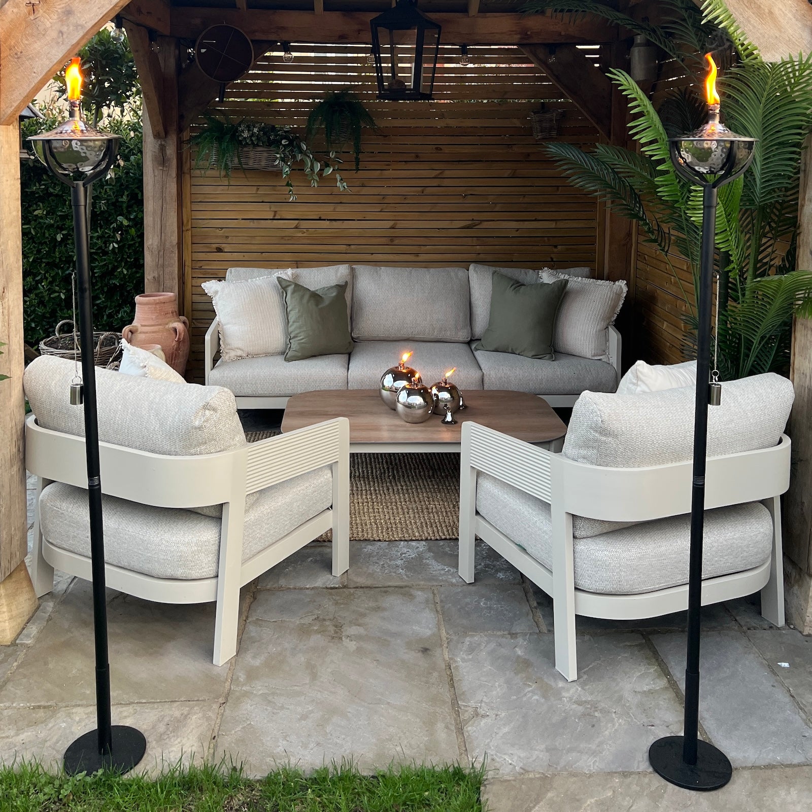 Under cover patio seating area with sofas and oil torches