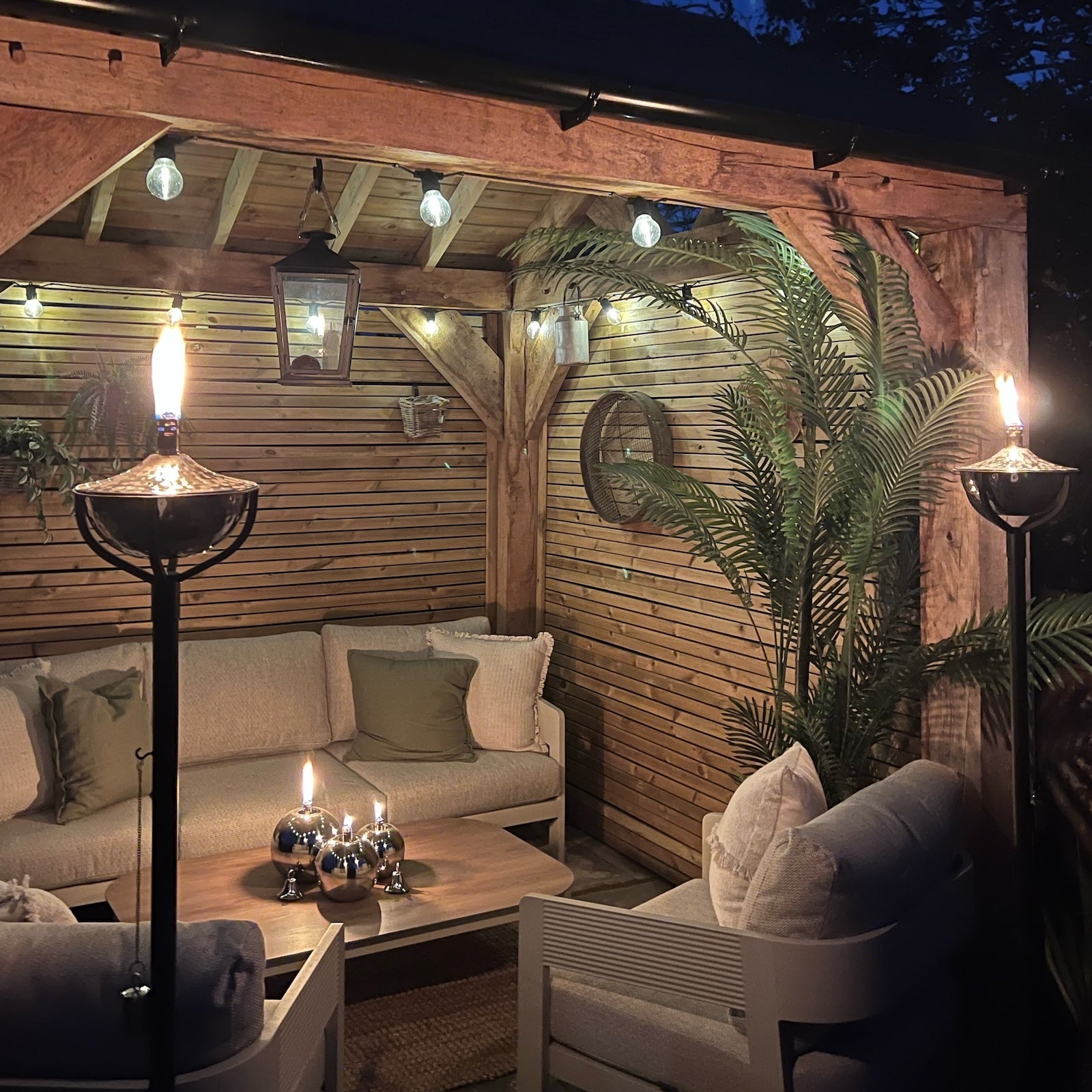 Patio seating area with garden tiki torches lit