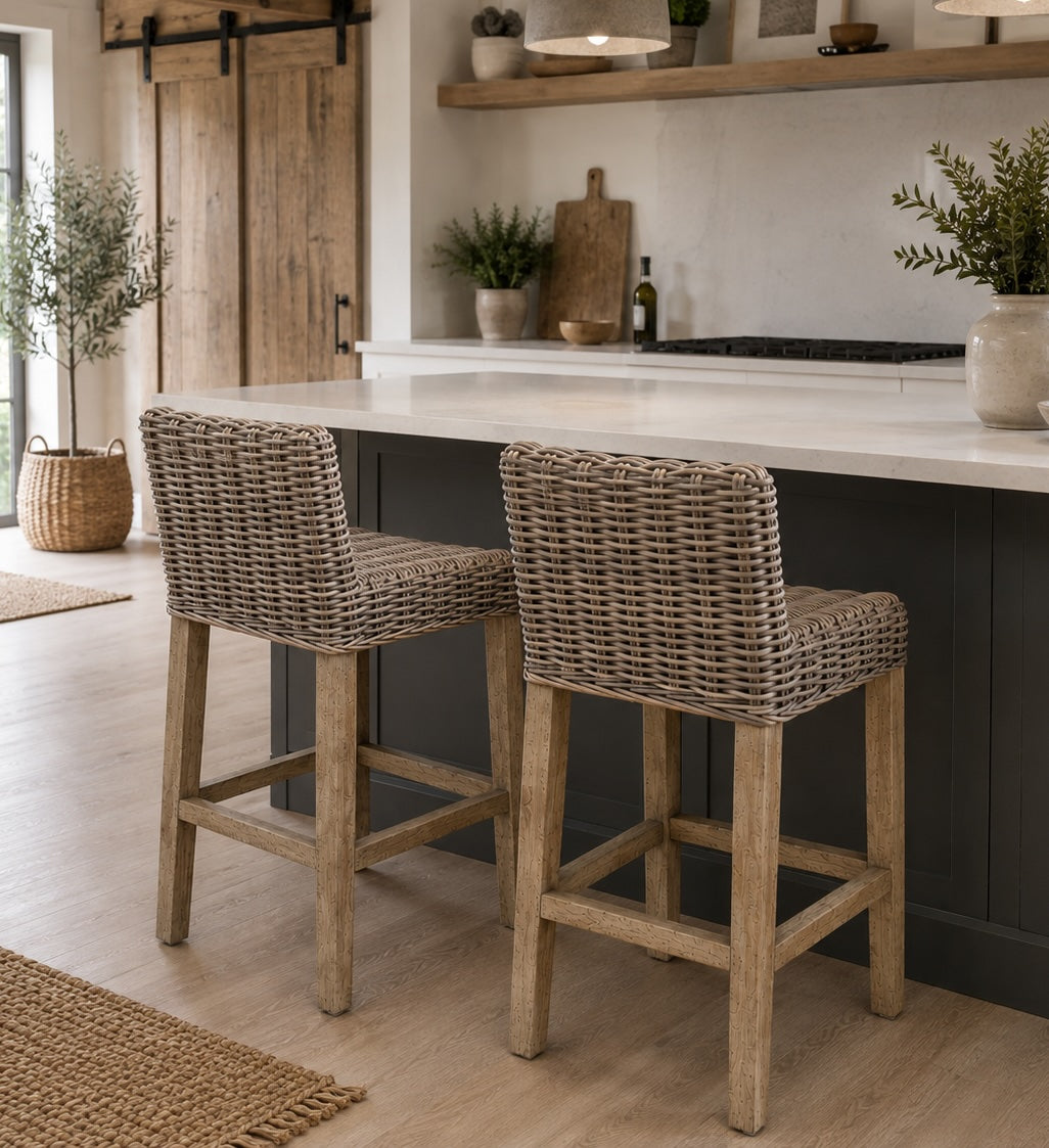 two rattan kitchen stools at marble kitchen island with plants and wicker rug