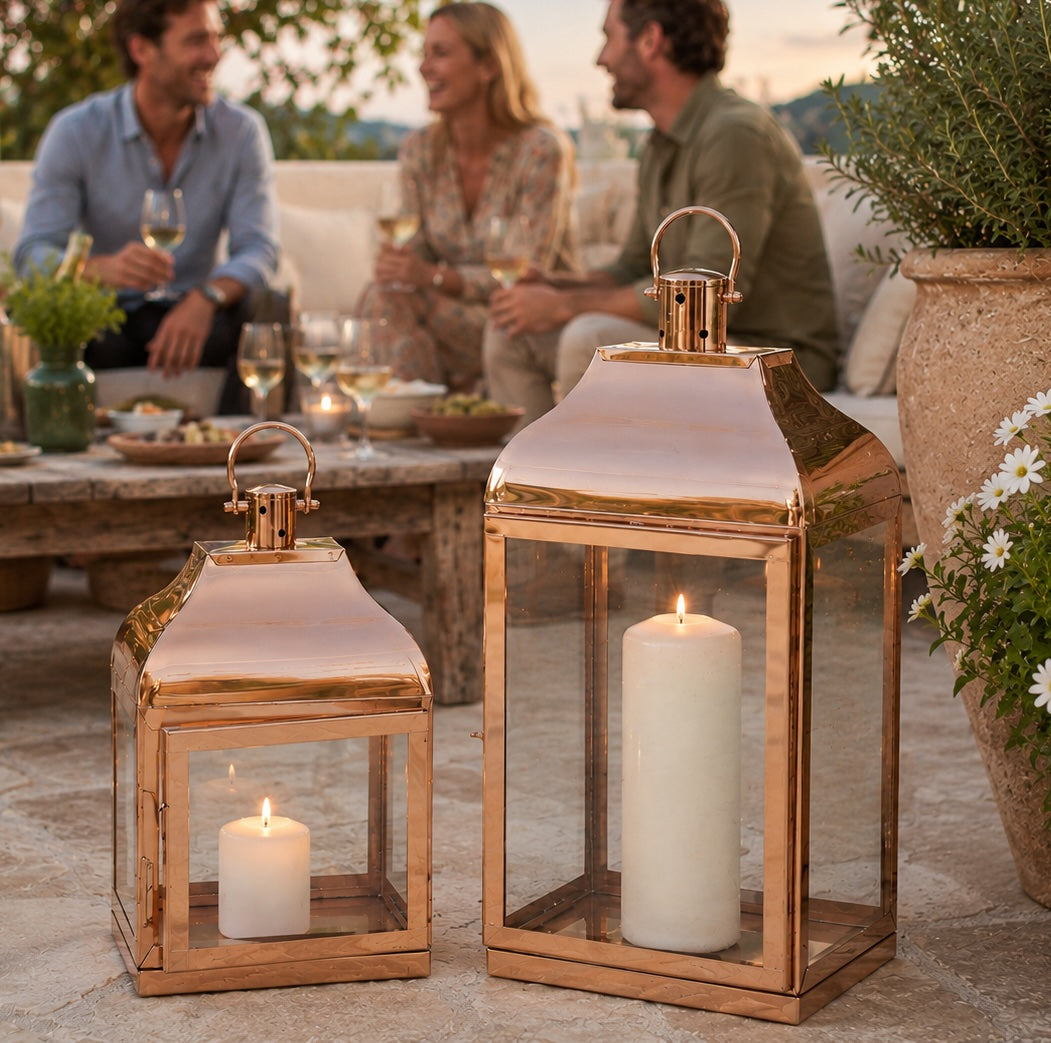 copper candle lanterns on patio with people talking behind