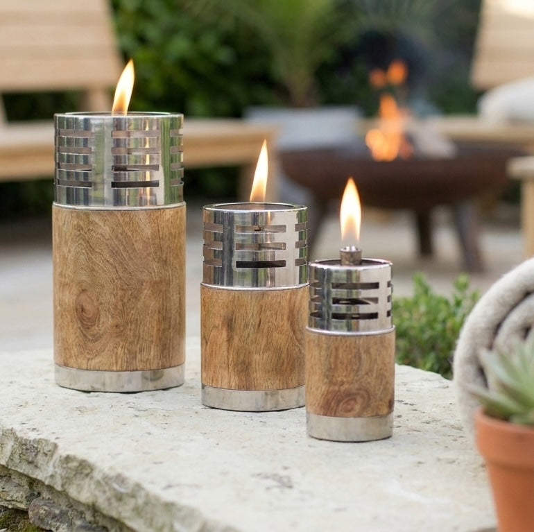 Three oil lamps outdoors on stone wall
