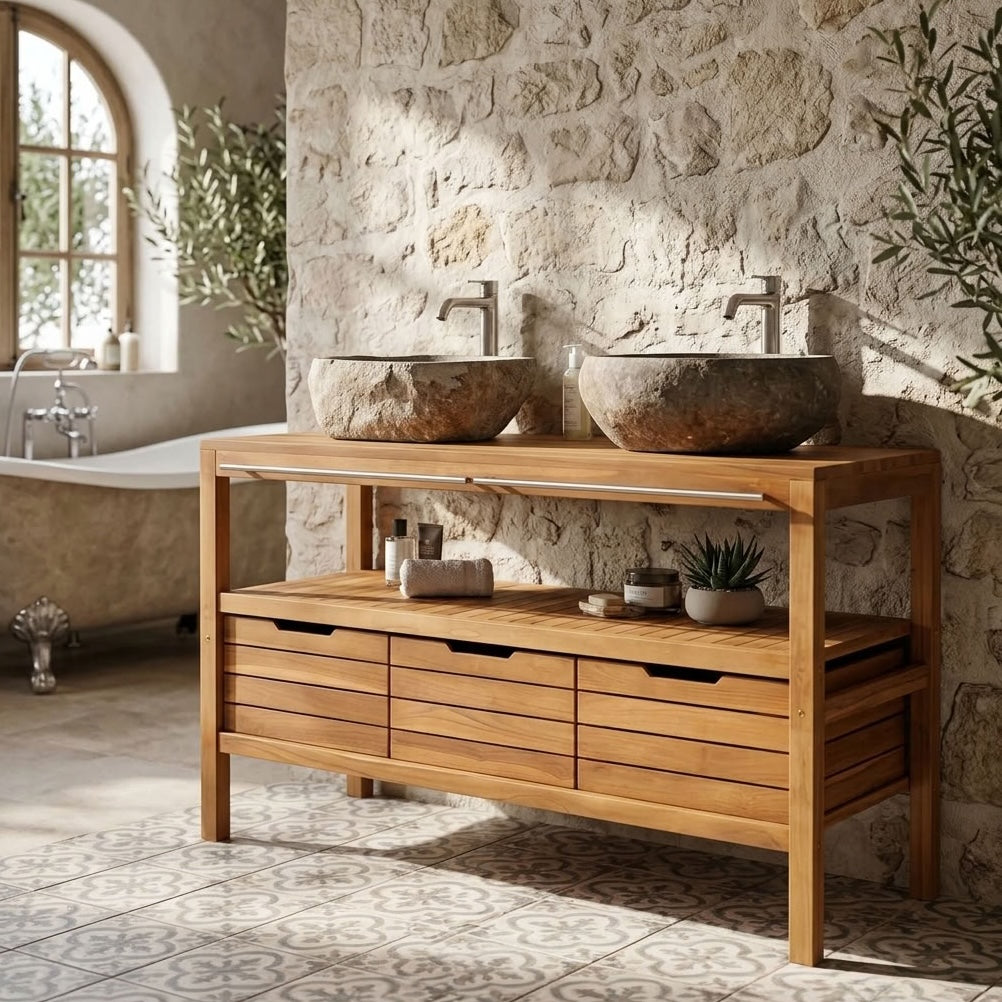 A wooden double-sink bathroom vanity with an open shelf and drawers, styled in a rustic stone bathroom setting.