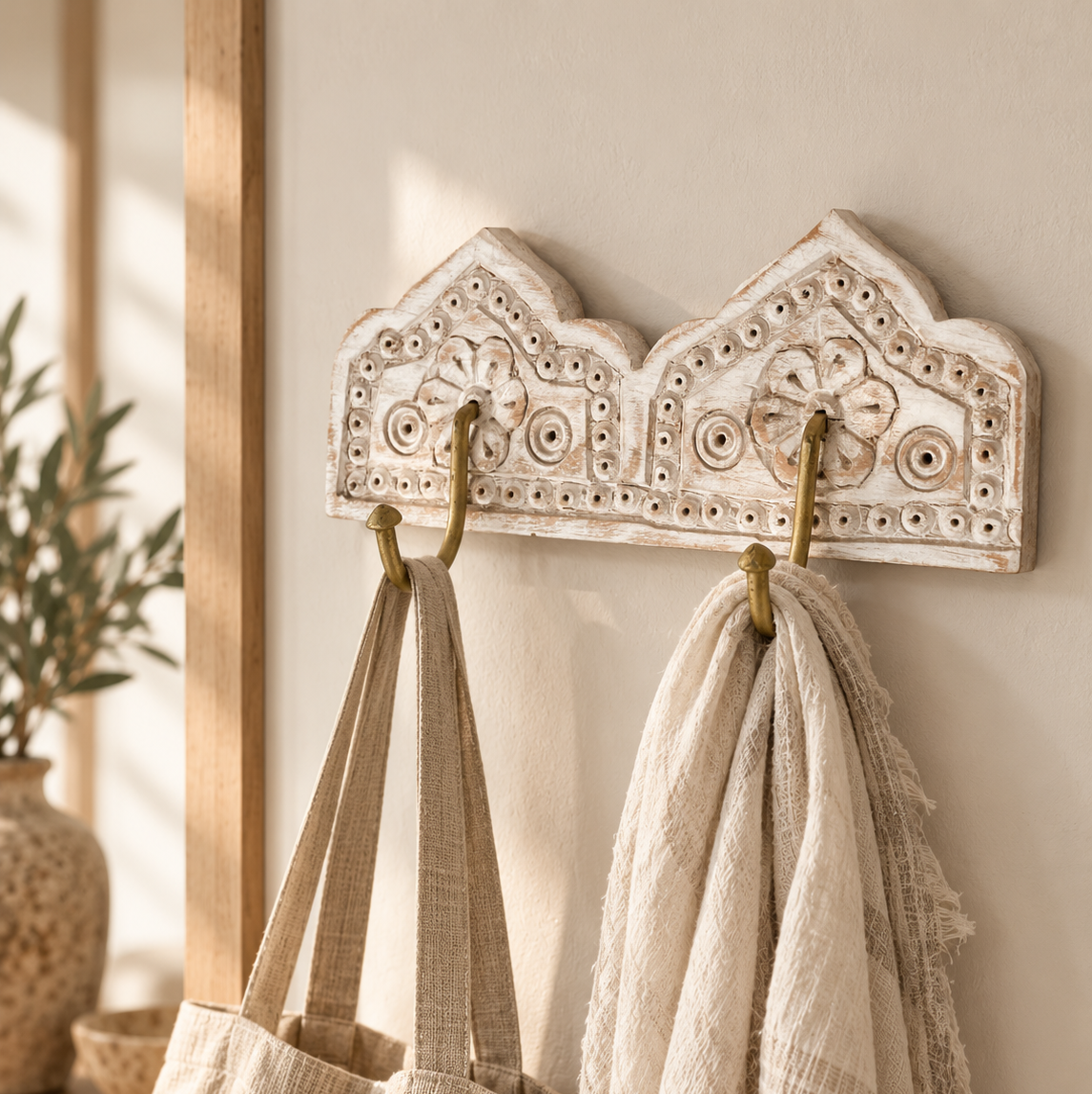 wooden bohemian style coat hooks, with scarves and bags hanging from the brass hooks.