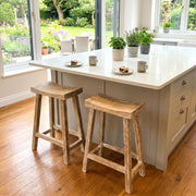kitchen with wooden floors, kitchen island and wooden breakfast bar stools