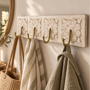 white rustic wooden coat hook with brass handles with wicker bag and clothes hanging off it