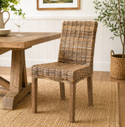 Natural Wicker dining chair next to a table on a rug in a dining room