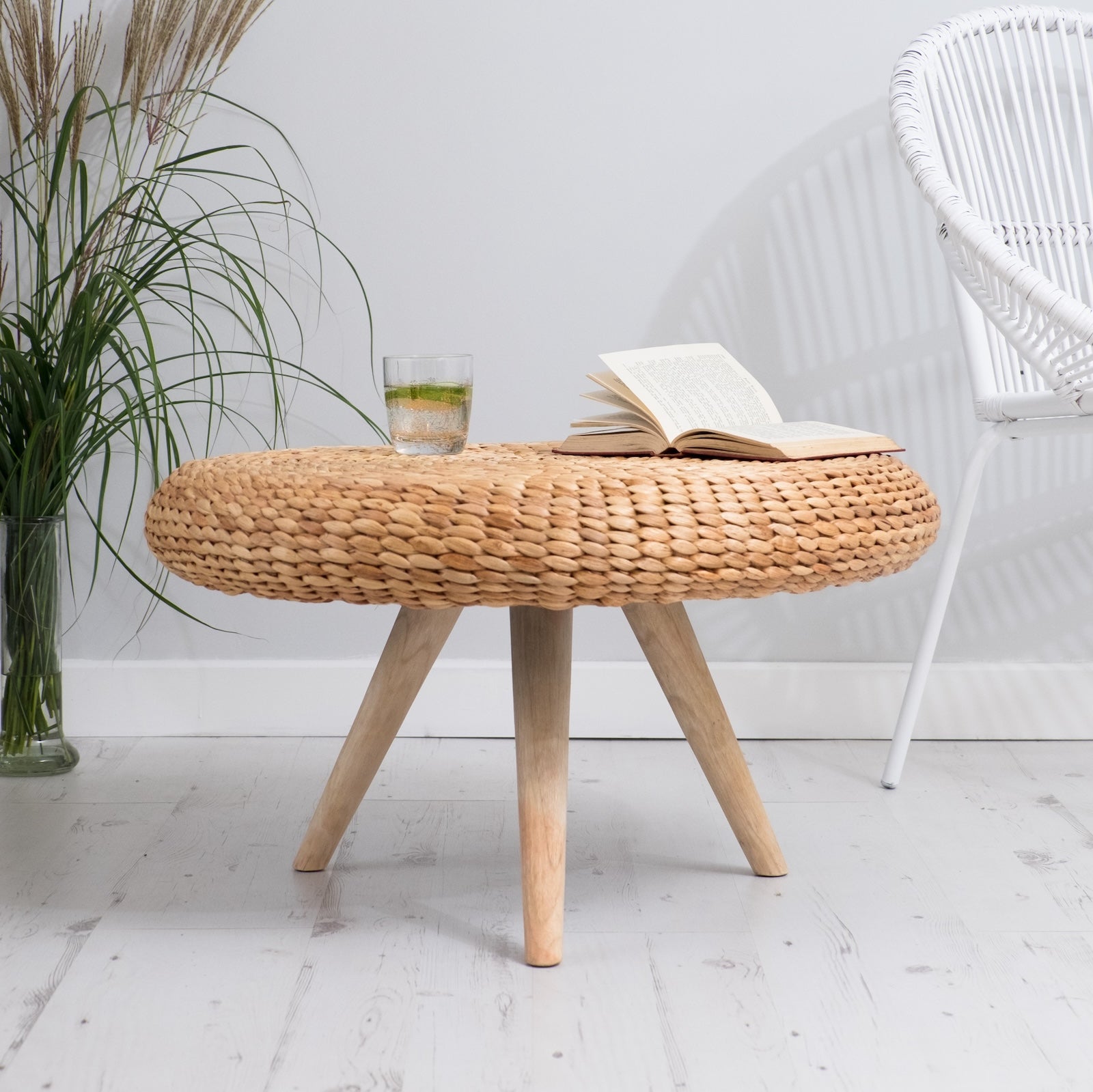 Wicker coffee table in living room with plant and white chair