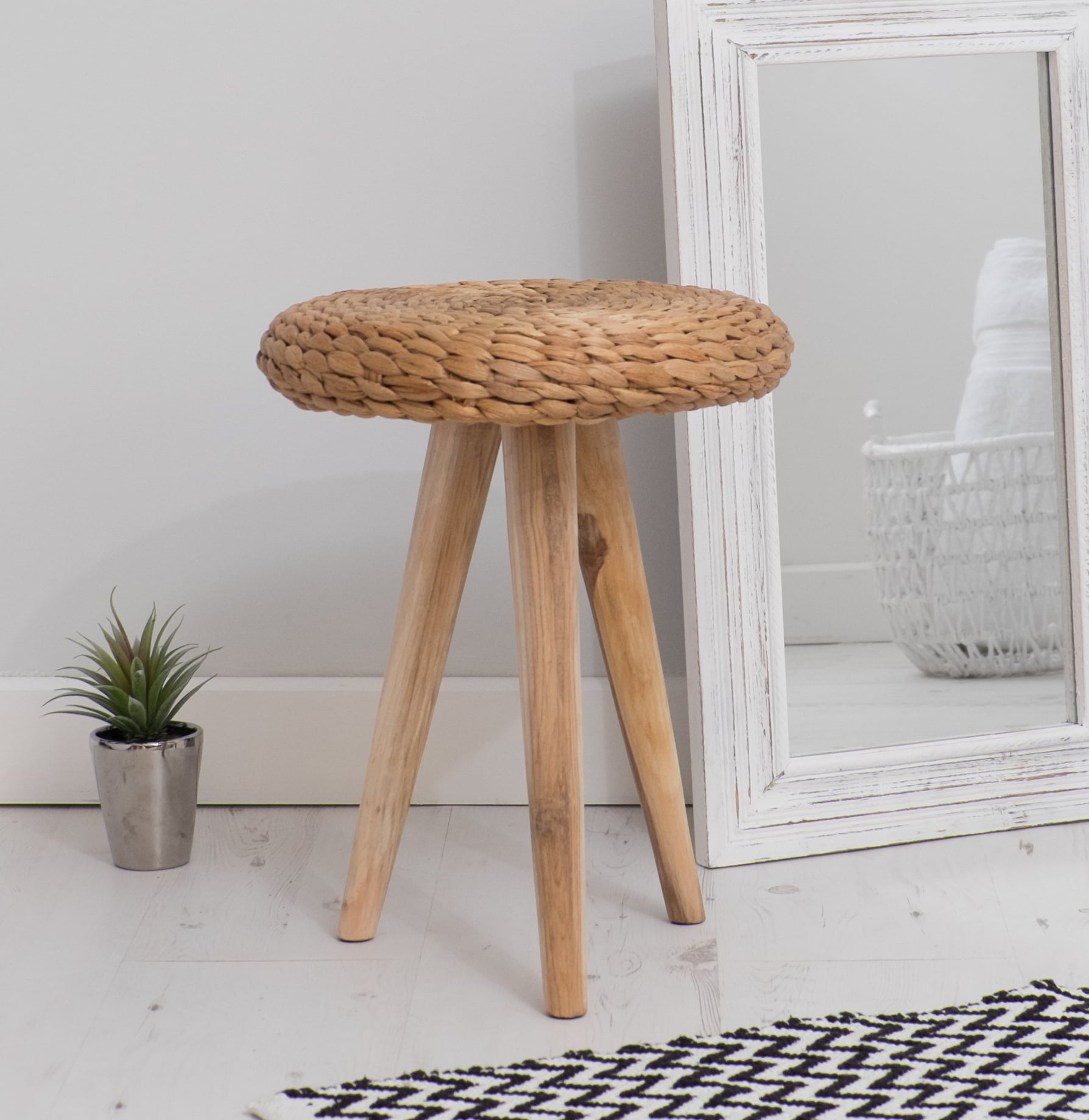 wicker foot stool with mirror and plant
