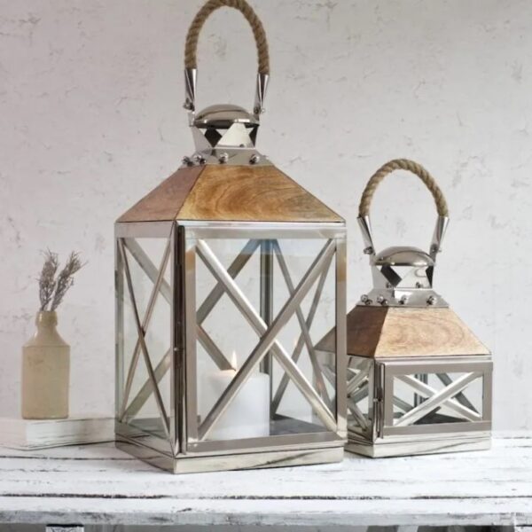 large silver candle lanterns on white wooden shelf