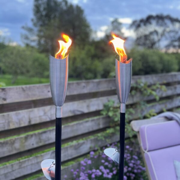 Outdoor silver citronella oil lantern in garden with chair and nature