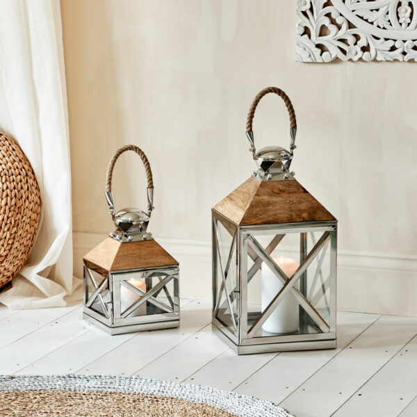 Silver and mango wood lanterns on wooden floor with rug