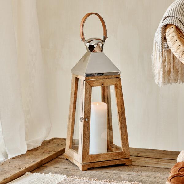 Tall silver and mango wood indoor candle lantern on wooden table