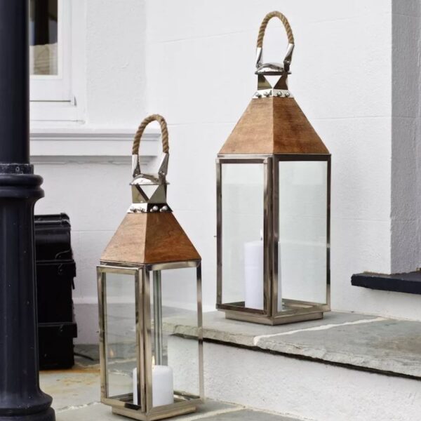 Tall silver candle lantern on front steps of house